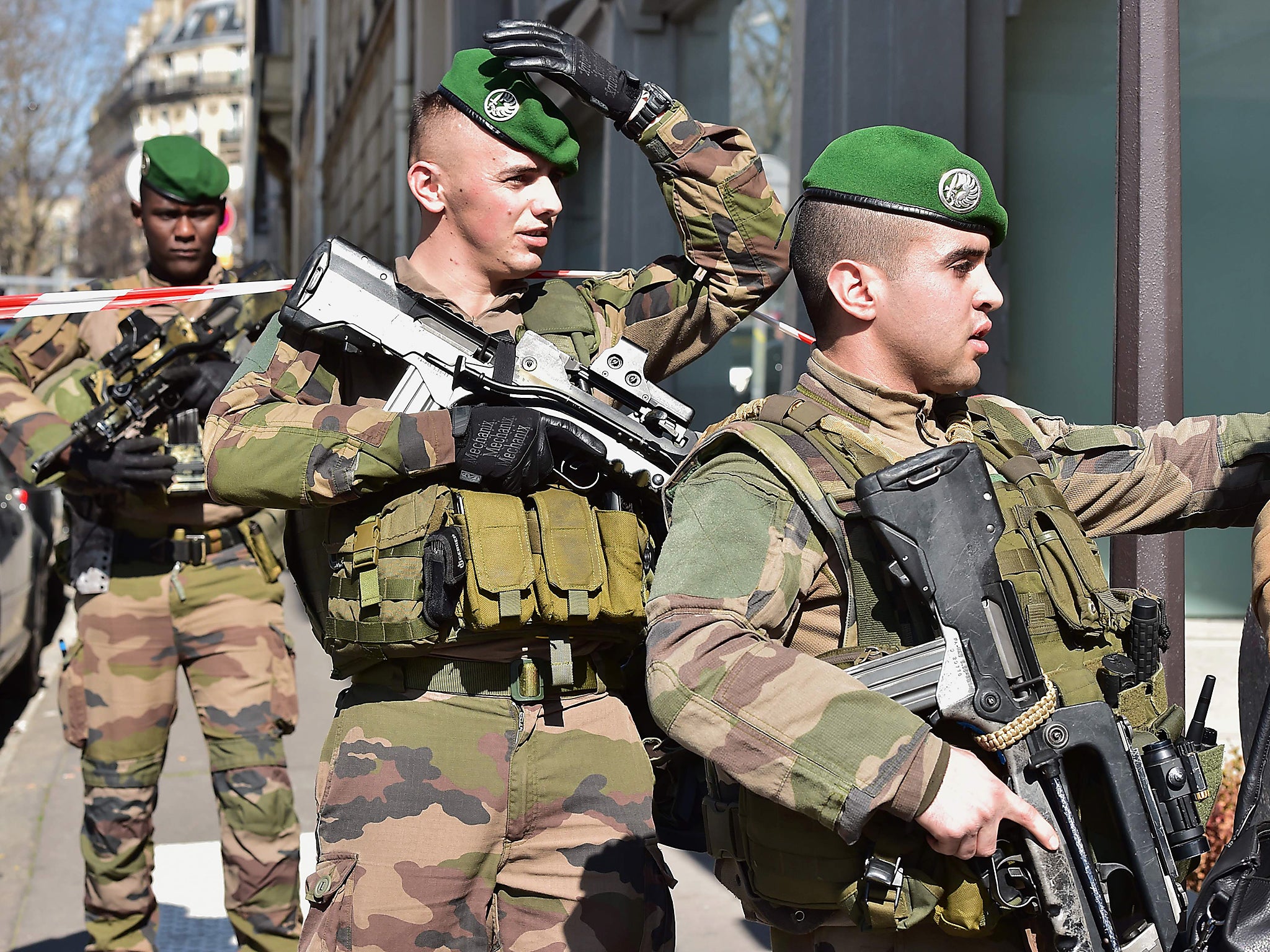 A French Army soldier talks to a woman as soldiers arrive at the scene near the Paris offices of the International Monetary Fund (IMF) in Paris, after a letter bomb exploded in the premises