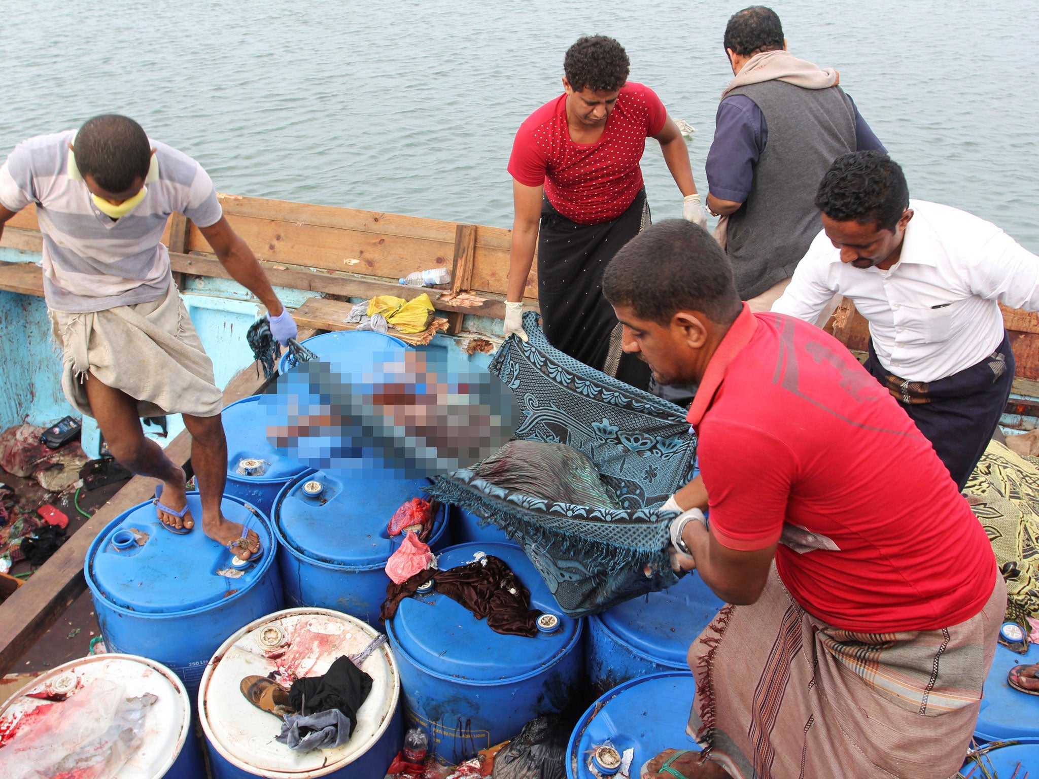 People carry the body of a Somali refugee, killed in attack by a helicopter while travelling in a vessel off Yemen, at the Red Sea port of Hodeidah, Yemen, 17 March