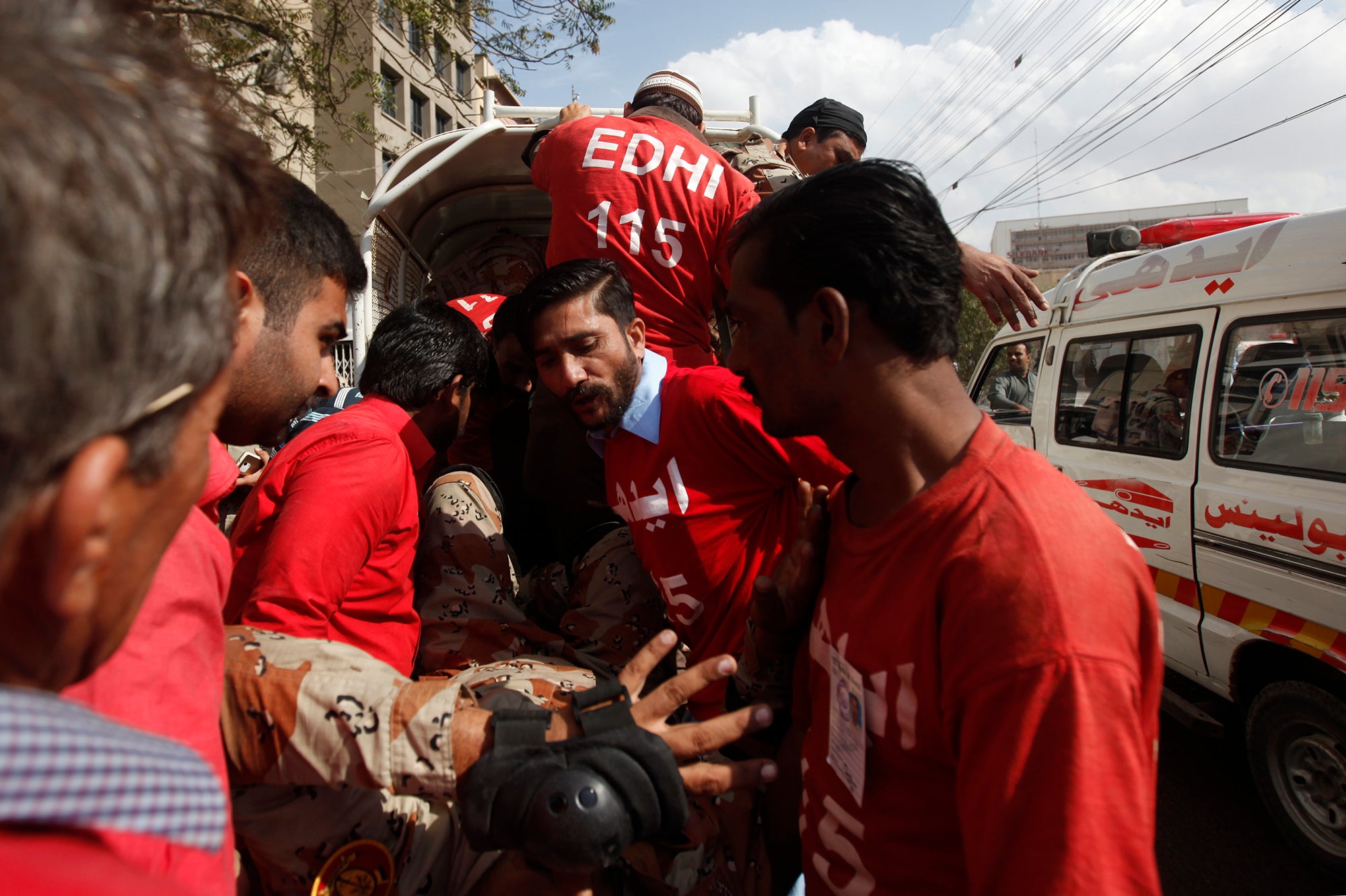 Safdar (centre) transports an injured paramilitary soldier who slipped from his bike