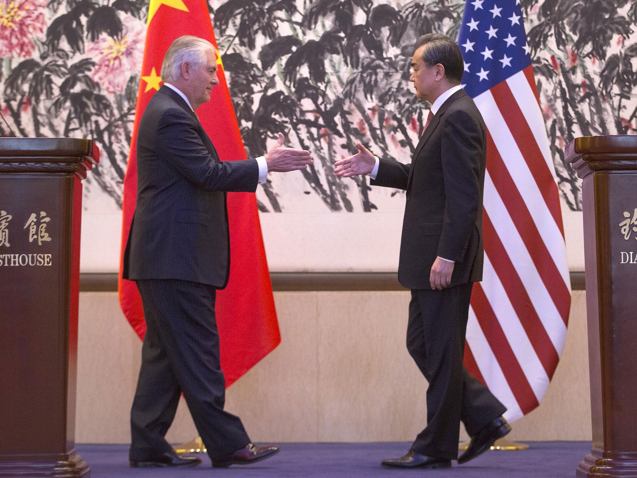 &#13;
Chinese Foreign Minister Wang Yi (R) shakes hands with US Secretary of State Rex Tillerson after a joint press conference in Beijing, China (Getty)&#13;