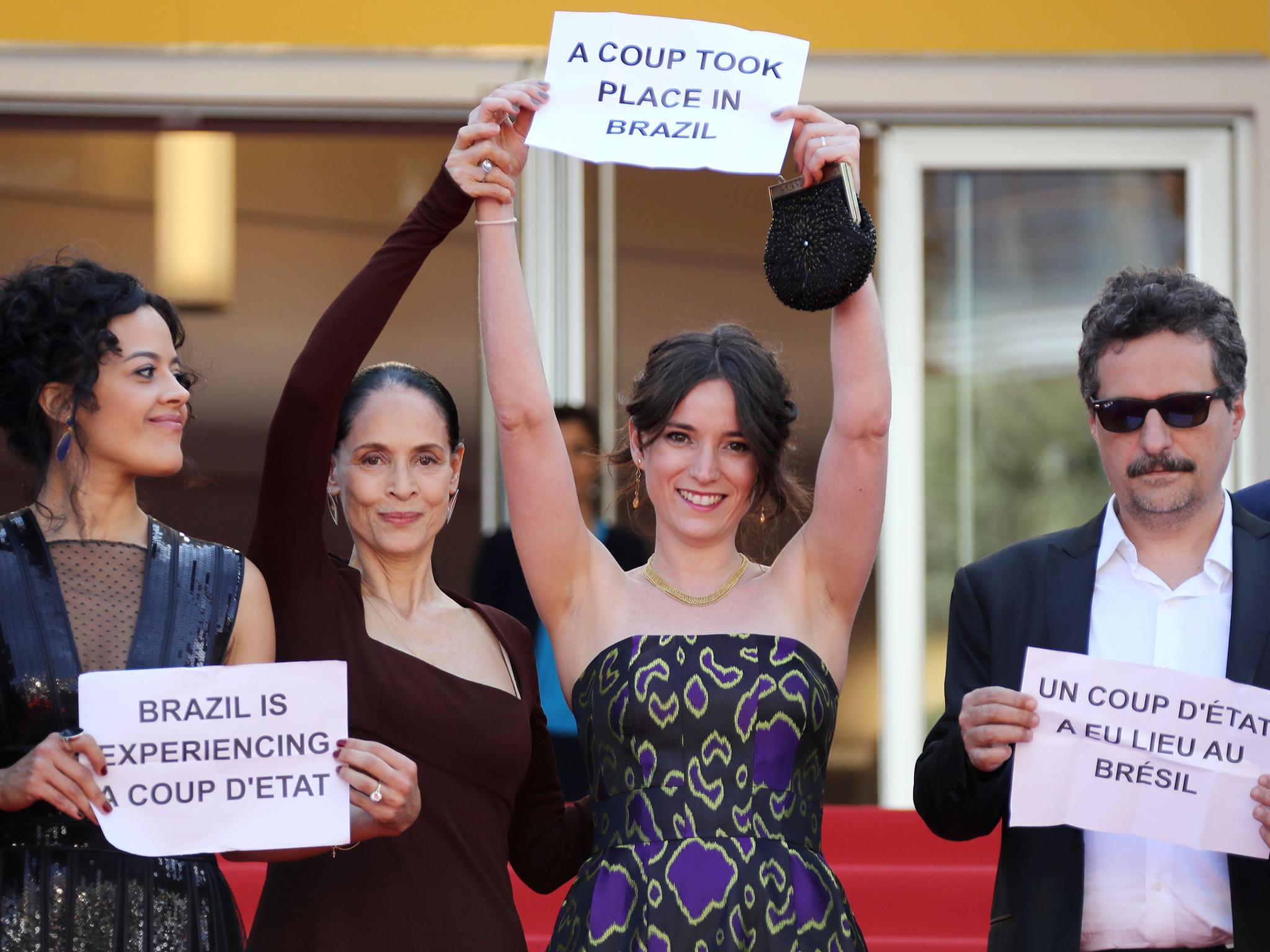 Maeve Jinkings, Sonia Braga, Emilie Lesclaux and Filho hold signs at the world premiere of 'Aquarius' at Cannes days after the Brazilian President Dilma Roussef was suspended