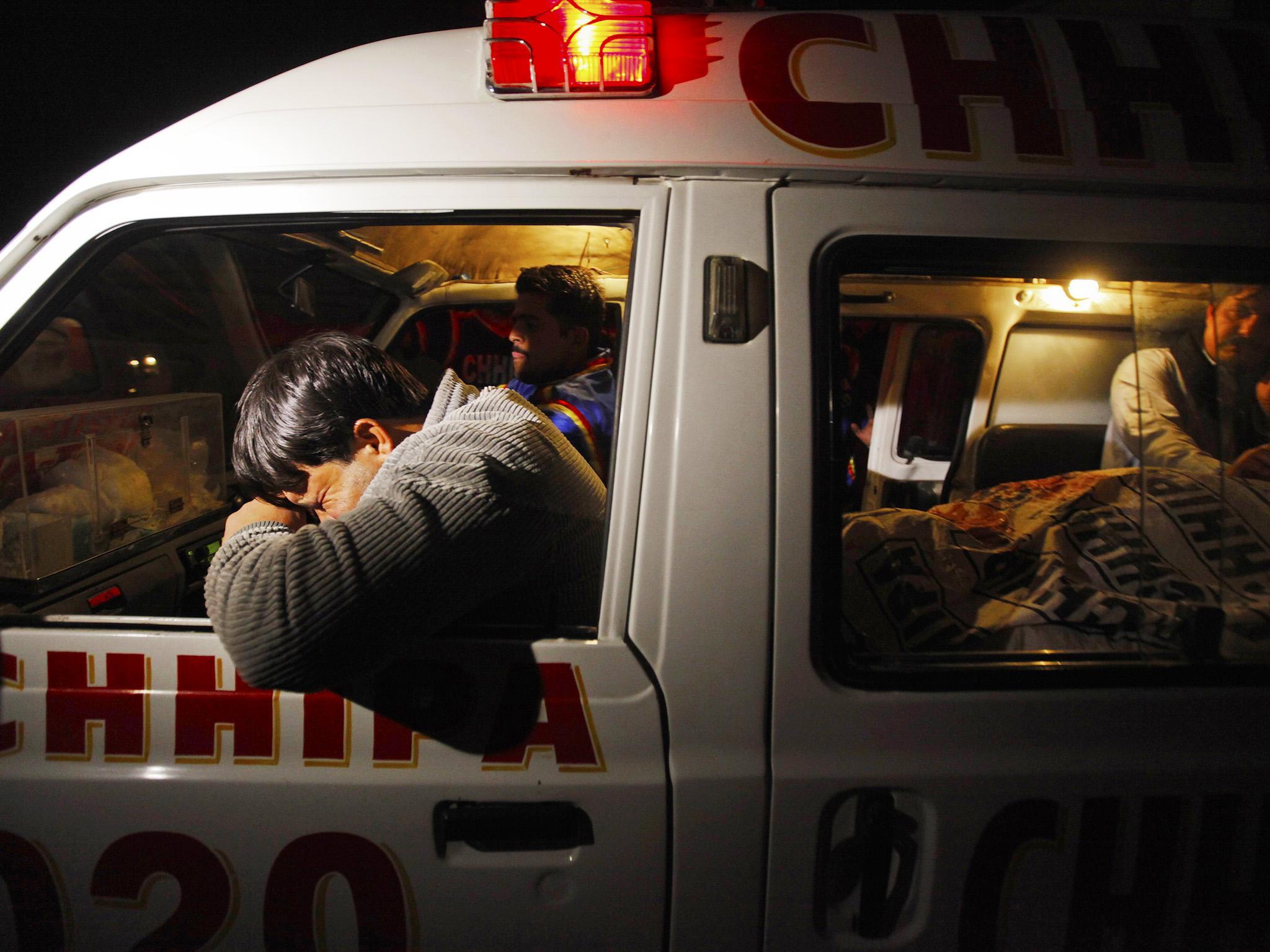 A relative mourns the death of a family member after a gunman killed six people in Baldia Town (Akhtar Soomro/Reuters)