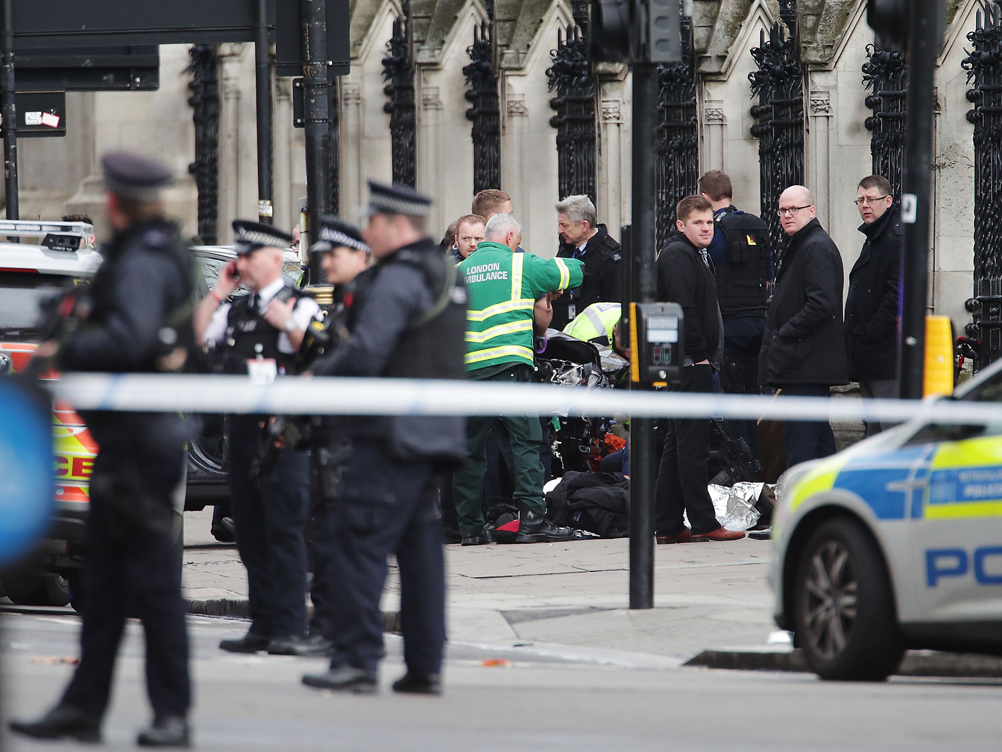 Paramedics treat an injured person on the pavement outside the Houses of Parliament