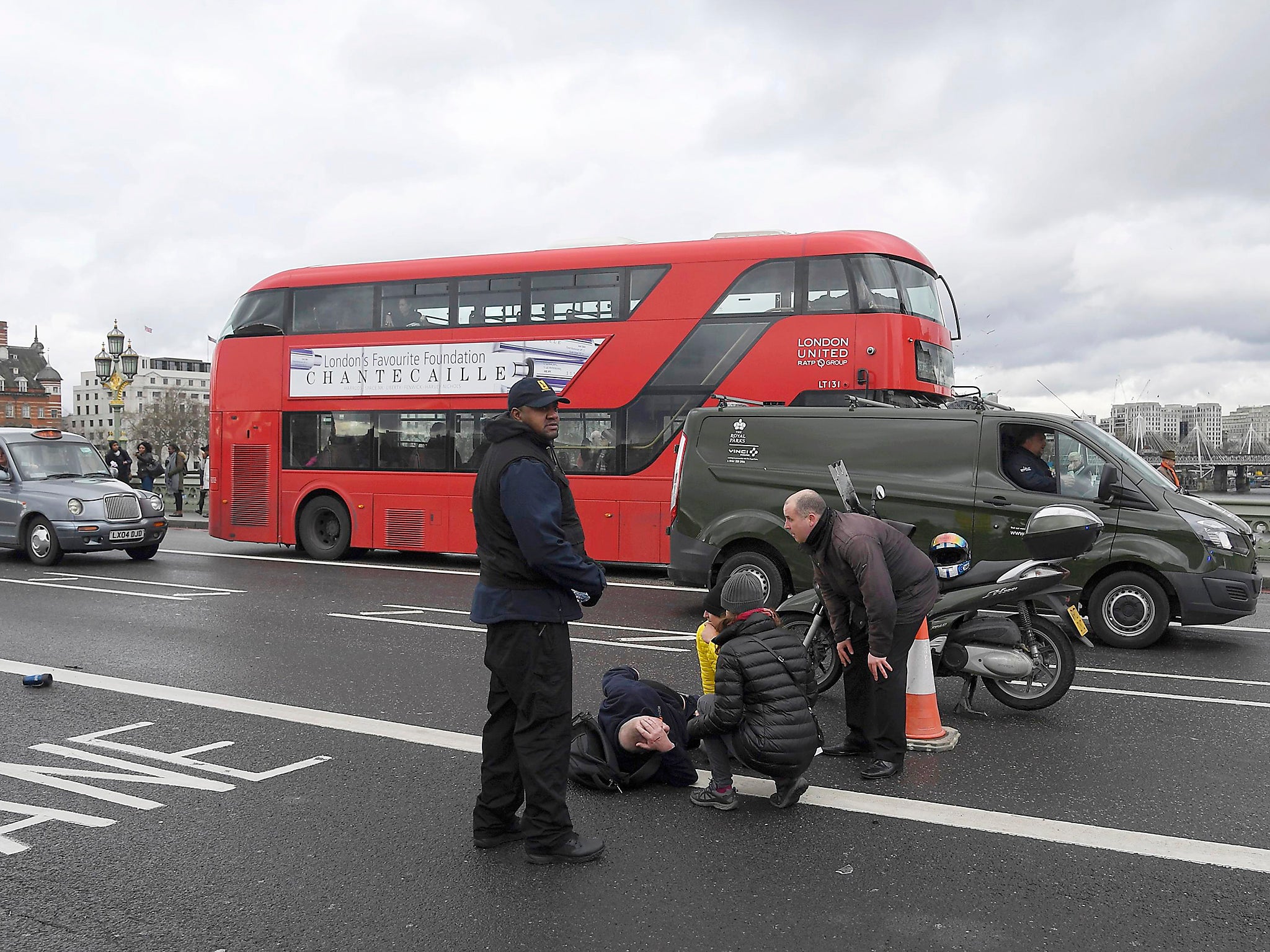 A victim lies in the road as passers-by comfort him, marking one many casualties in the trail of destruction left in the wake of the attacker's onslaught