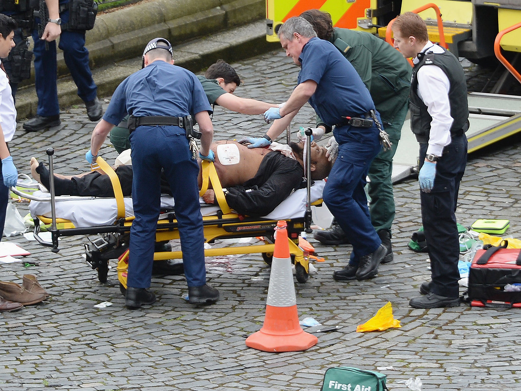 Emergency services at the scene in the immediate aftermath of the attack, as Masood is taken away in an ambulance