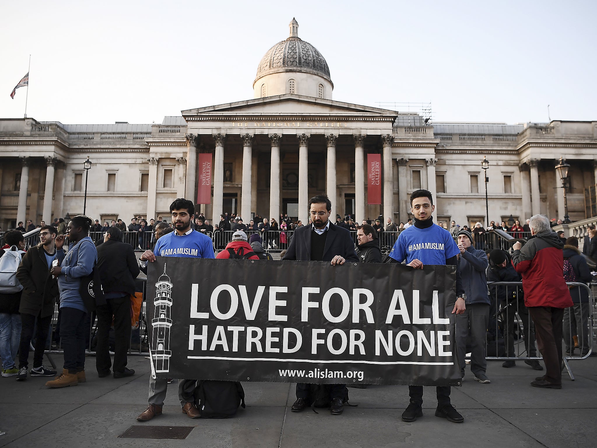 People hold up a banner ahead of a candlelit vigil at Trafalgar Square