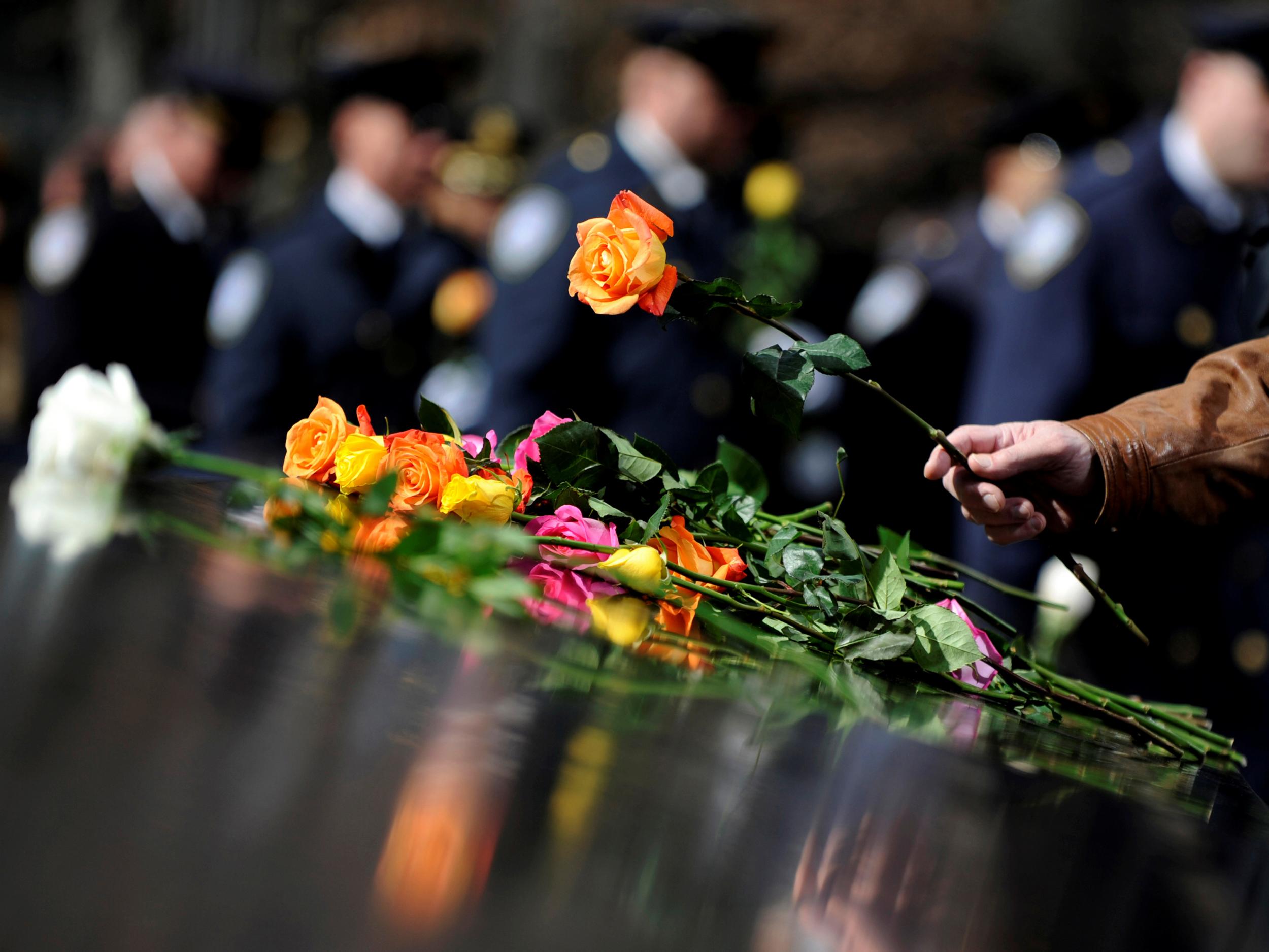 A family member lays a flower at a commemoration ceremony at the National September 11 Memorial & Museum at the World Trade Center site in Manhattan