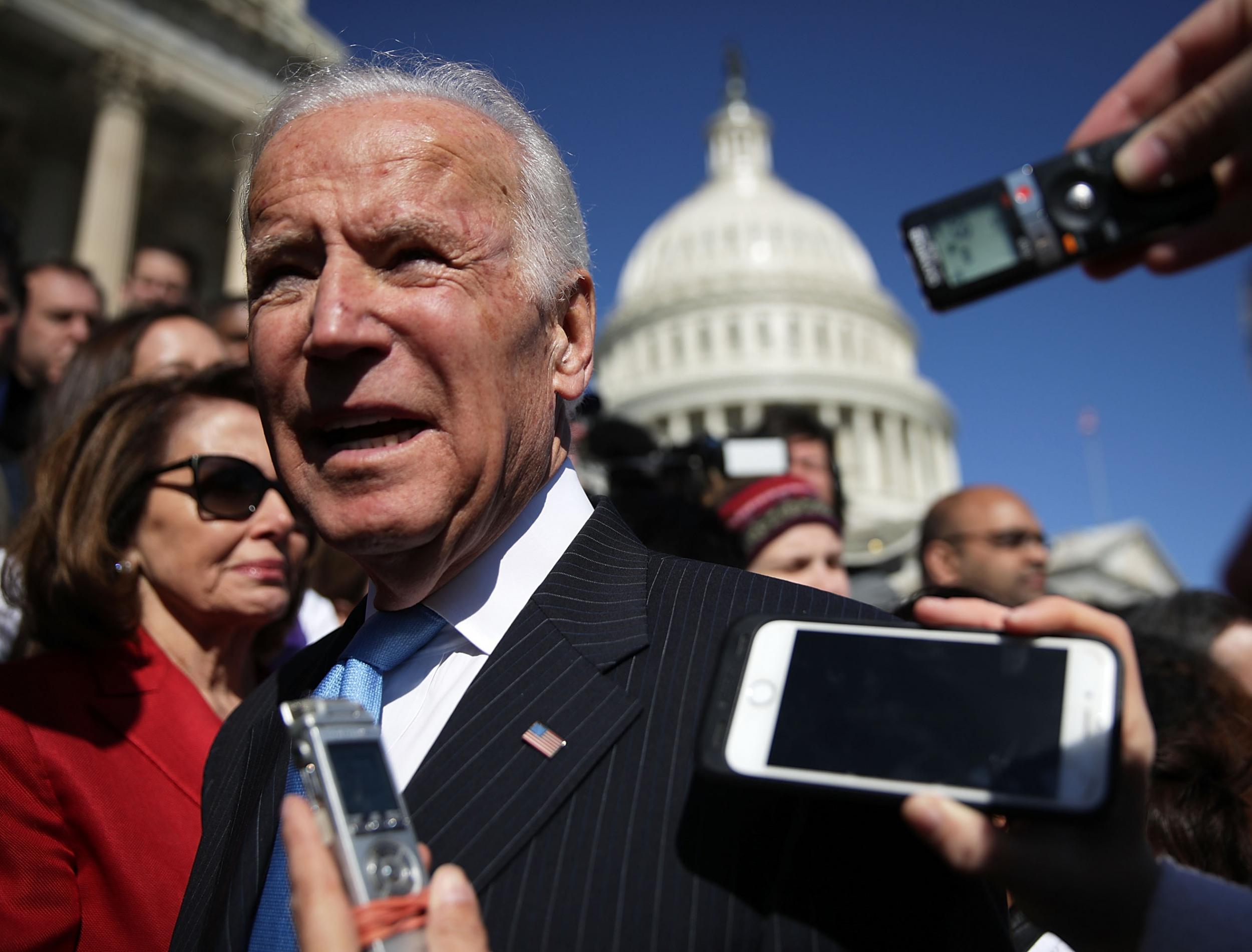 Joe Biden speak to journalists at a protest against the dismantling of Obamacare