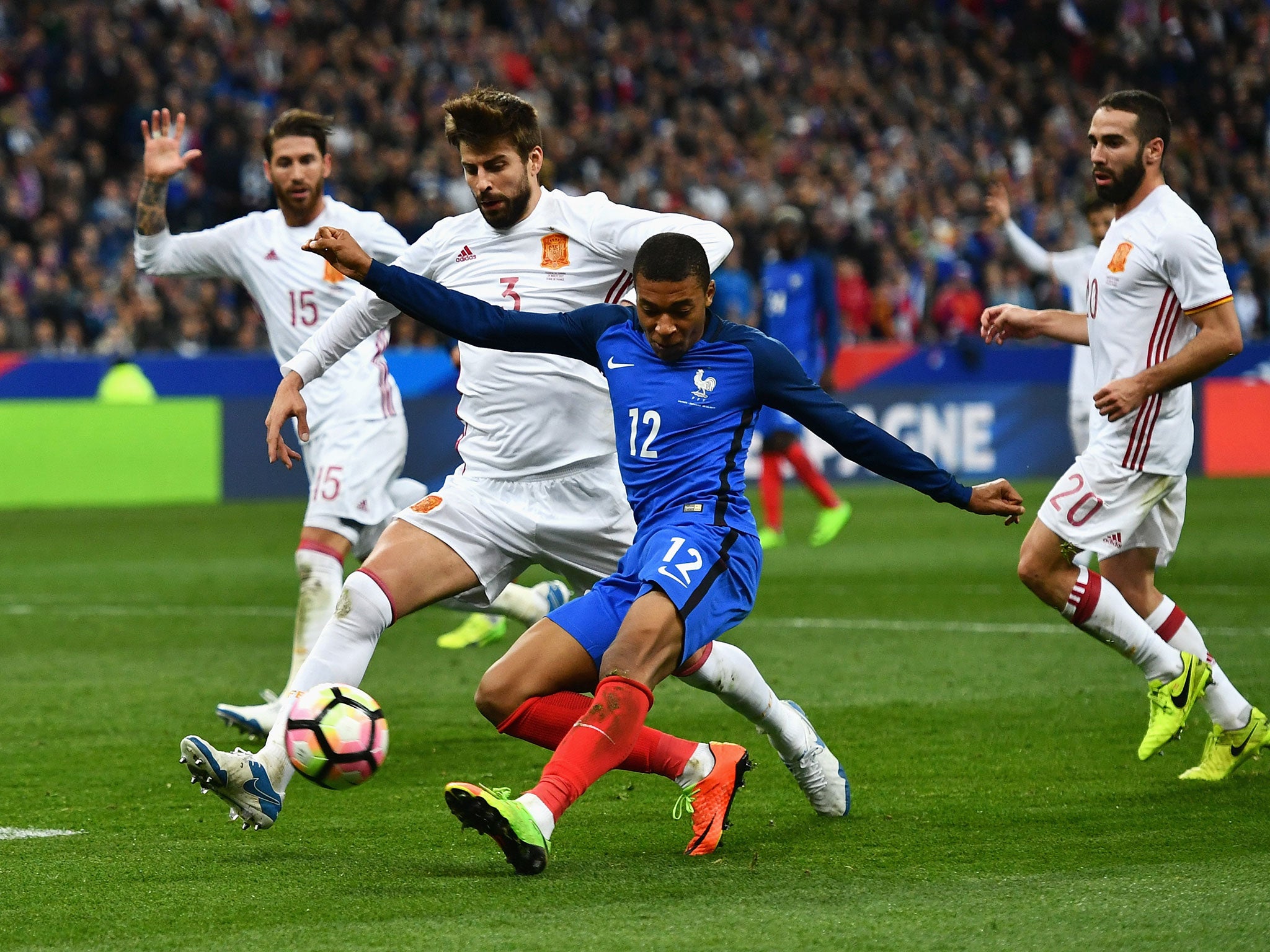 Piqué attempts to block a shot from Mbappe