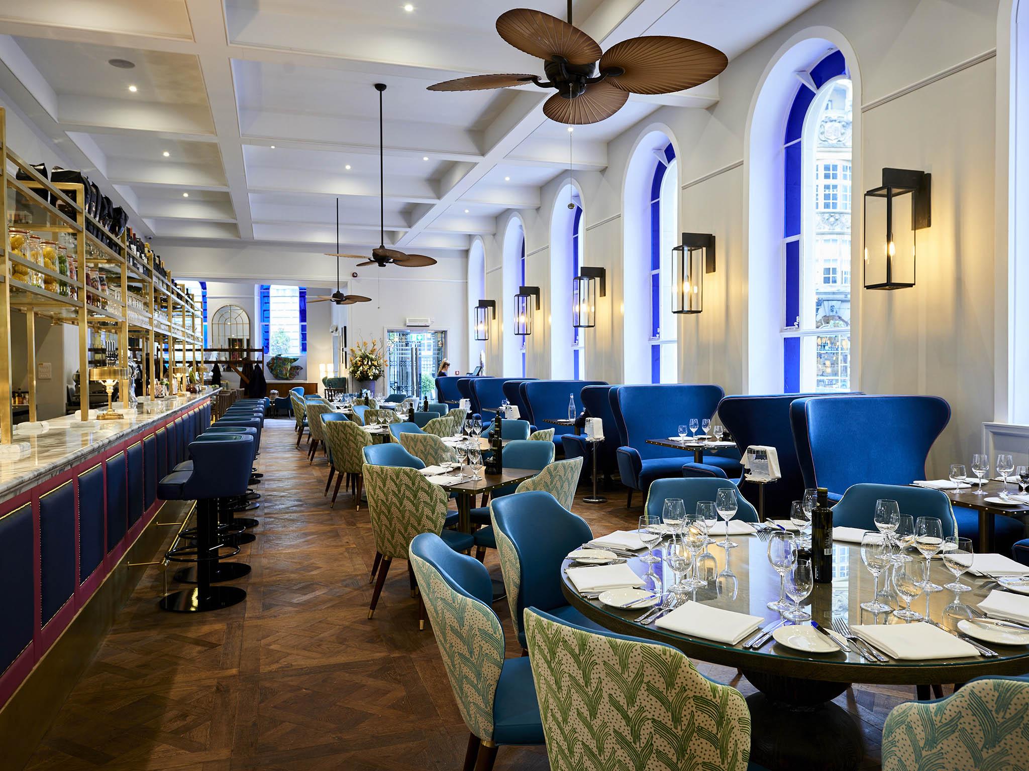 While bar stools line the marble-topped bar overlooking the kitchen, hanging Iberico hams and jars of preserves adorn it