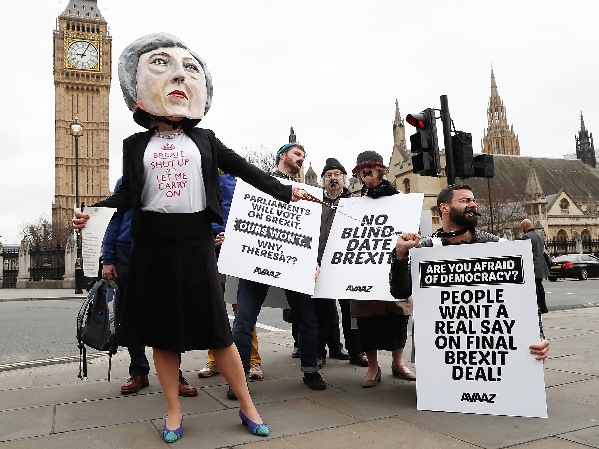 Anti-Brexit protesters, one wearing a giant Theresa May head, hold placards outside Parliament on the day the Prime Minister will announce that she has triggered the process by which Britain will leave the European Union