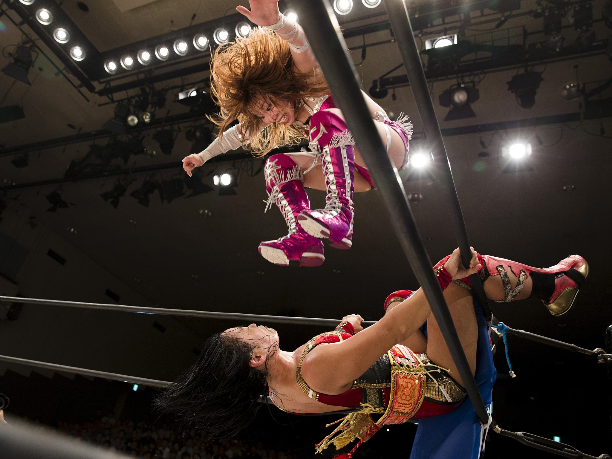 Wrestler Kairi Hojo jumps at her opponent Mieko Satomura during their Stardom female professional wrestling show at Korakuen Hall, Tokyo