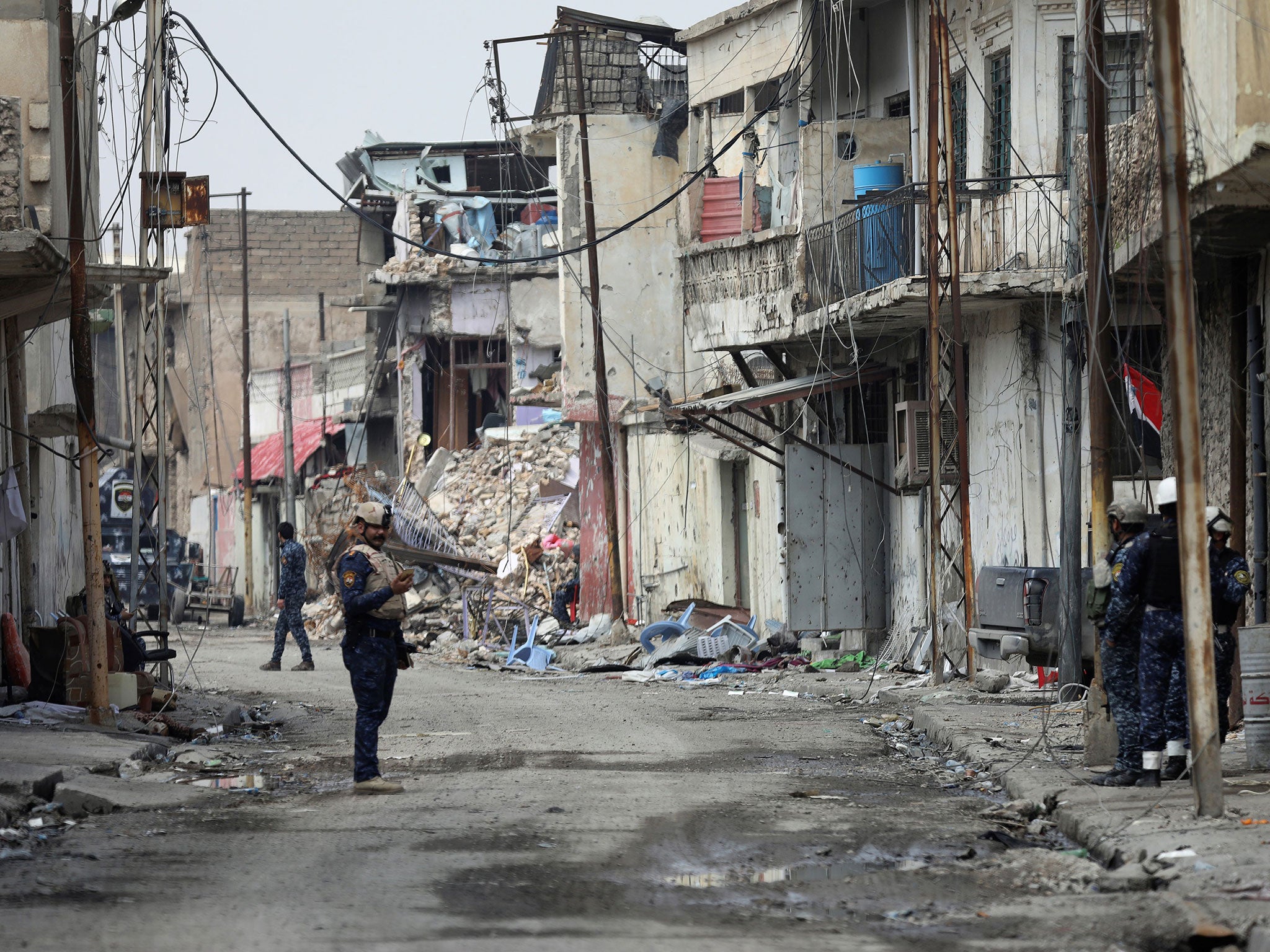 An Iraqi federal police officer stands guard on a Mosul street