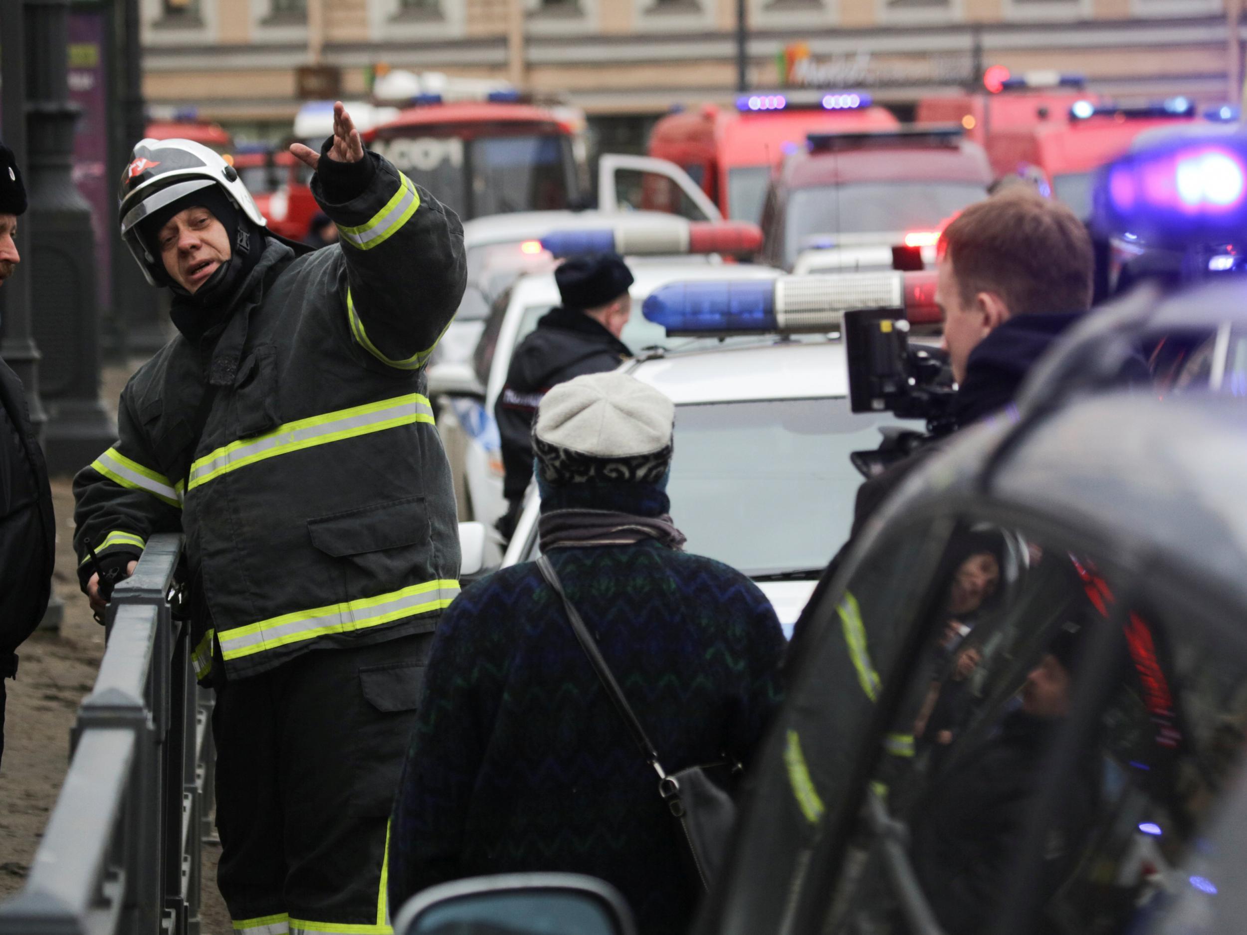 Emergency services direct pedestrians outside Sennaya Ploshchad metro station after an explosion that killed nine people