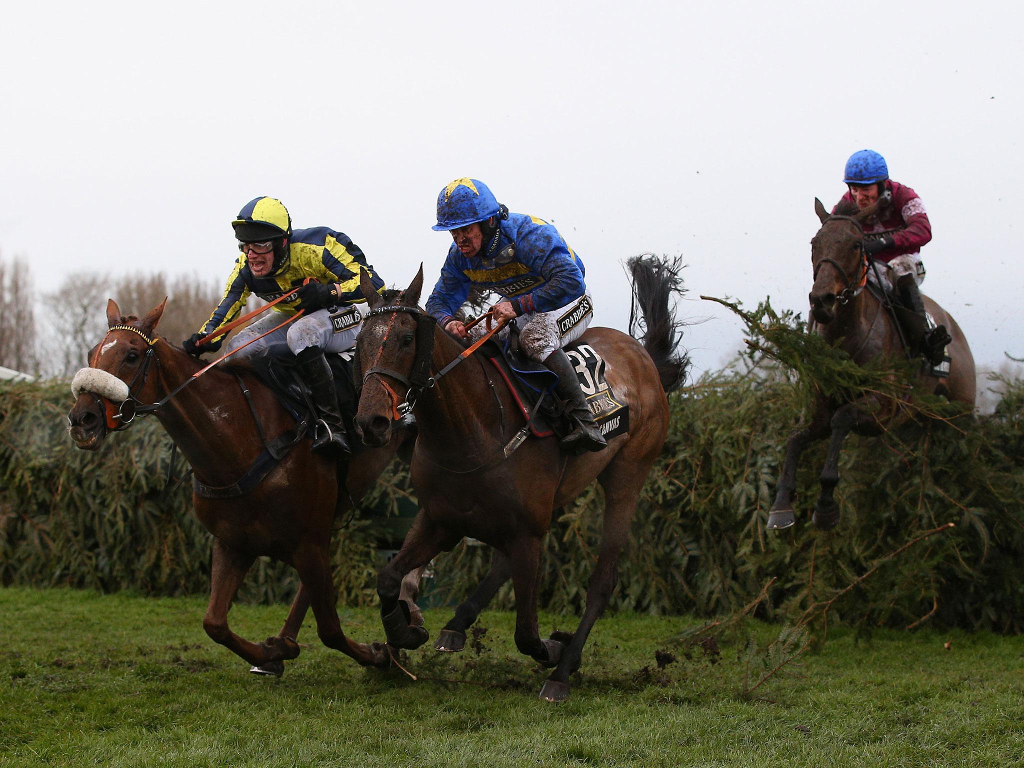 The Last Samuri ridden by David Bass and Vics Canvas ridden by Robert Dunne clear the last fence as eventual winner Rule The World ridden by David Mullins jumps it in third position during the Crabbie's Grand National Steeple Chase at Aintree