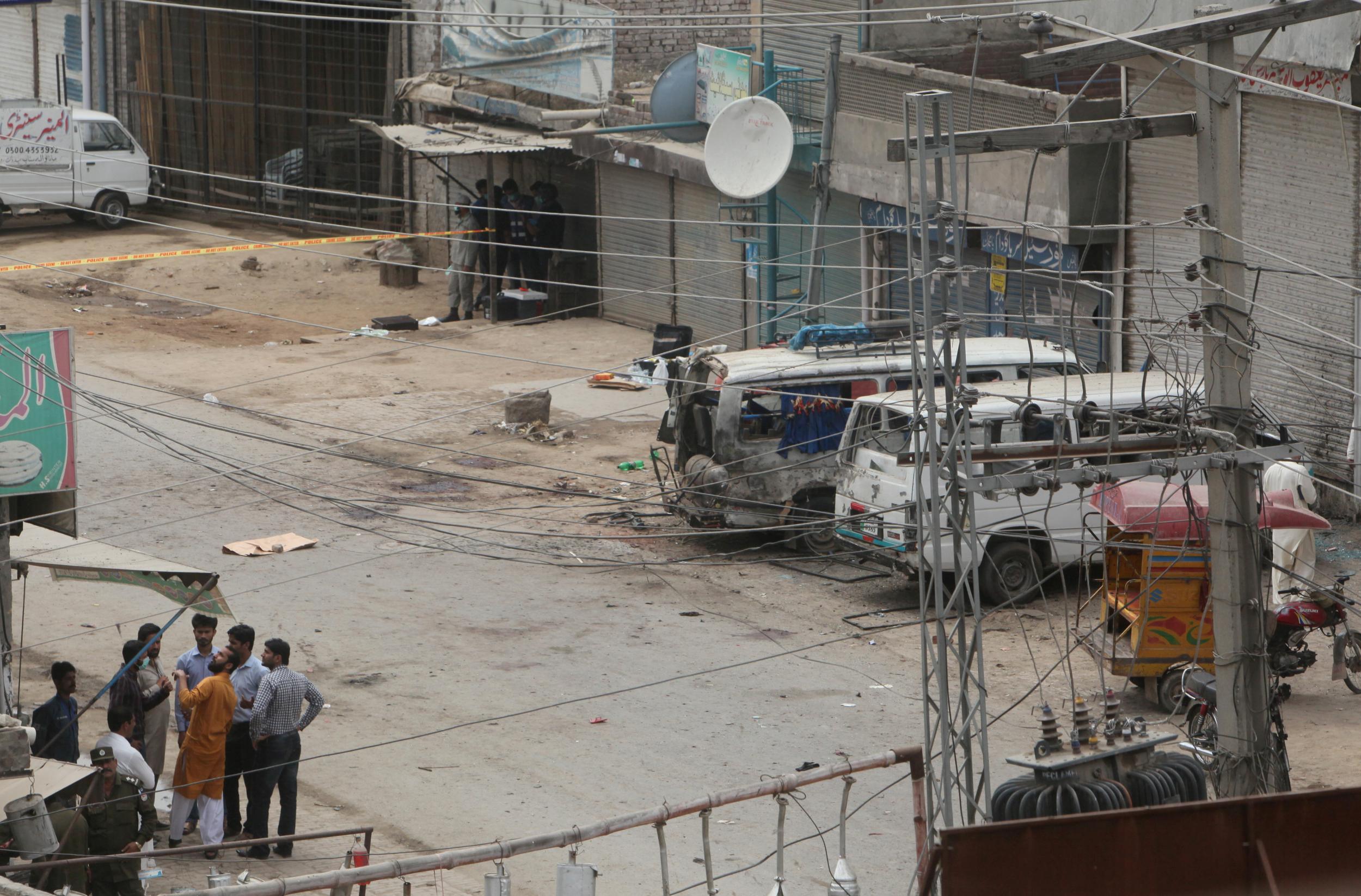 Security officials gather near the site of an explosion, near vehicles taking part in census, in Lahore on April 5 2017