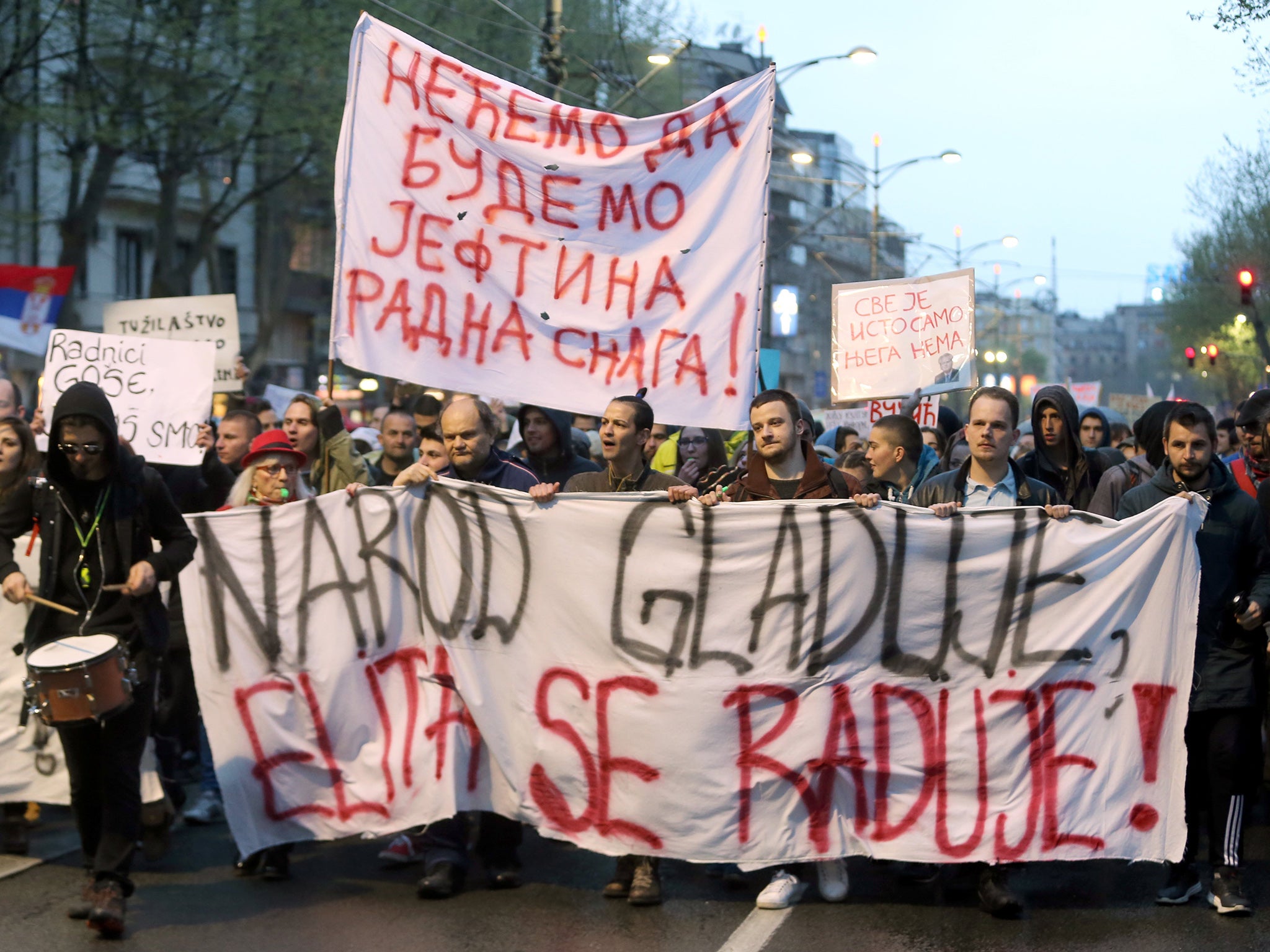 ‘People are hungry and elite celebrate,’ one protest sign reads