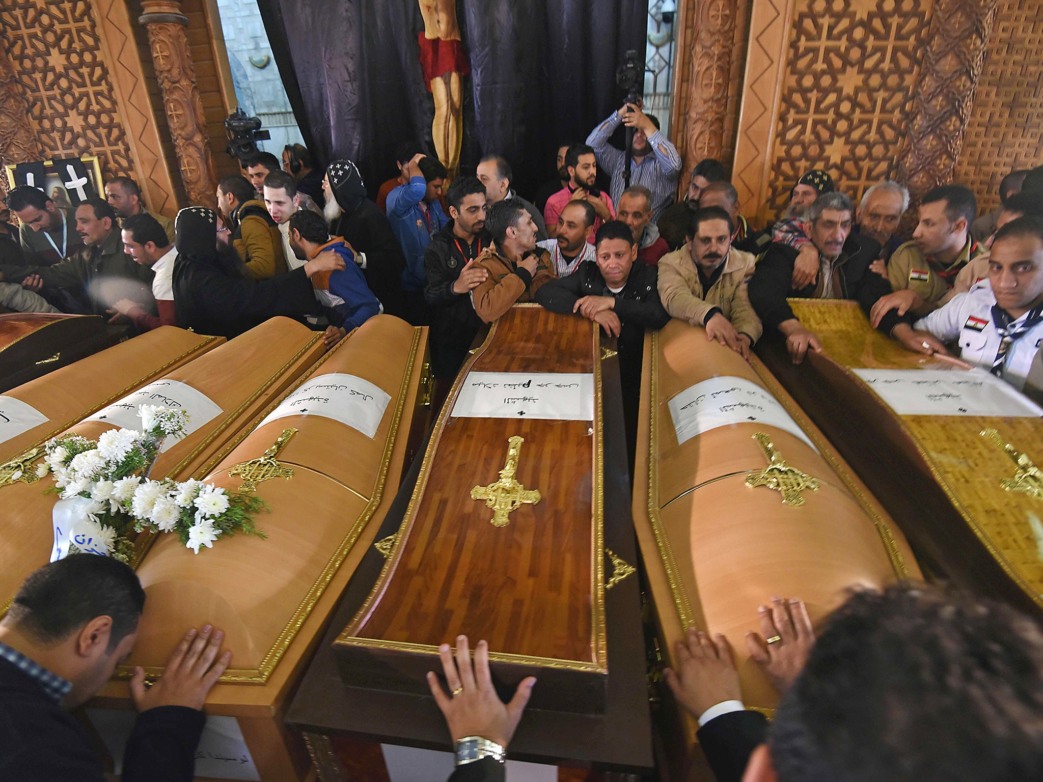 Mourners pray next to coffins of victims of the blast at the Coptic Christian Saint Mark's church in Alexandria during a funeral procession at the Monastery of Marmina in the city of Borg El-Arab (Getty)