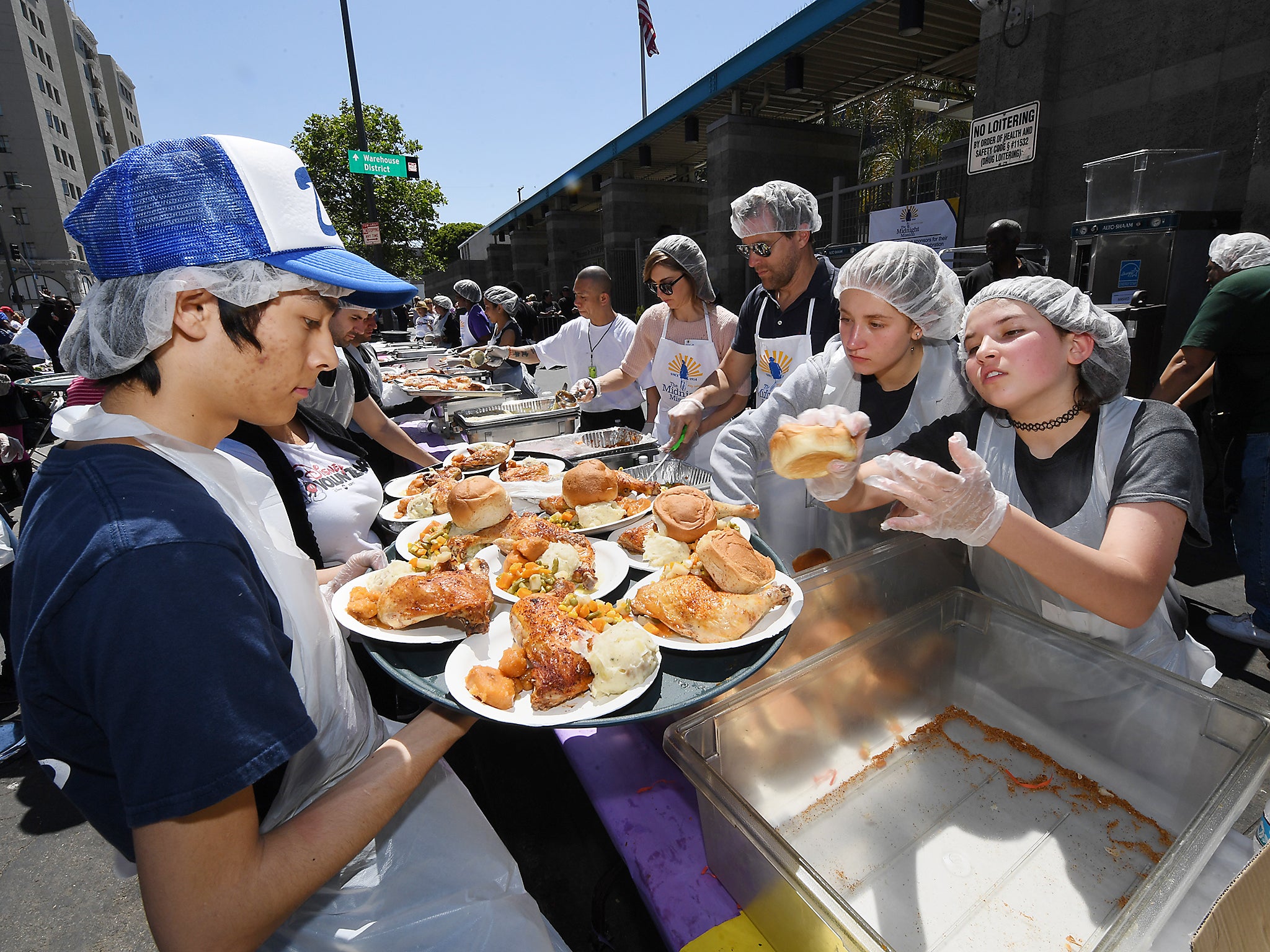 Volunteers from the Midnight Mission help feed the homeless and poor during its annual Easter/Passover celebration at Skid Row in Los Angeles, California