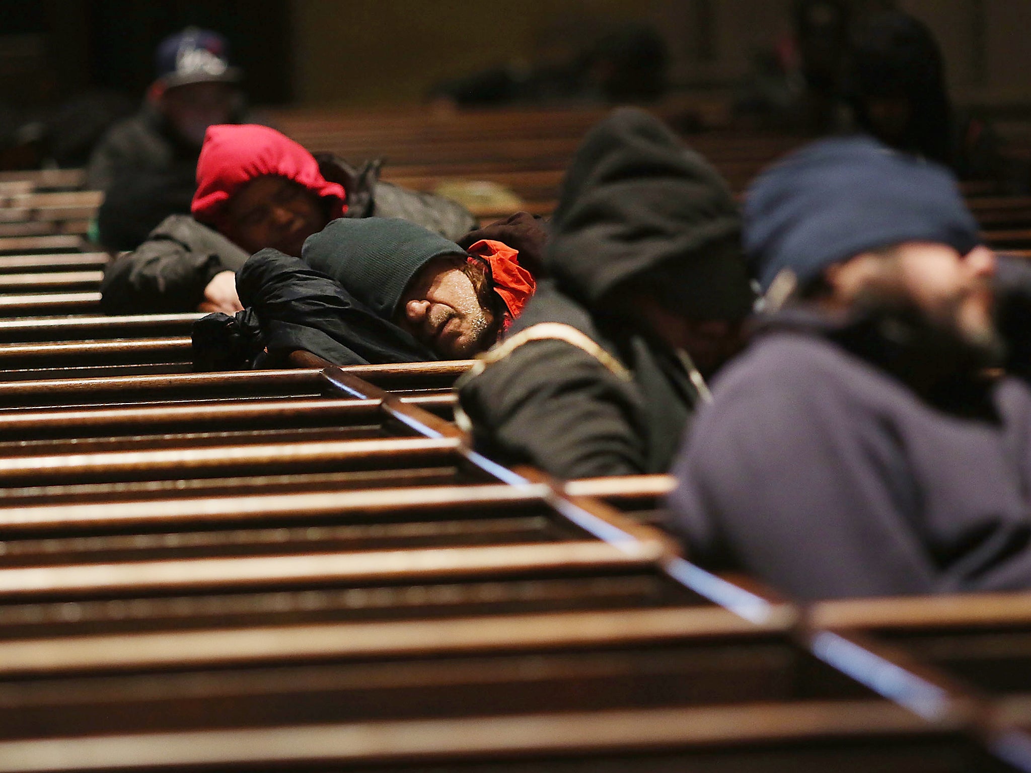 Homeless men try to stay warm in a Manhattan church on an unseasonably cold day in New York City