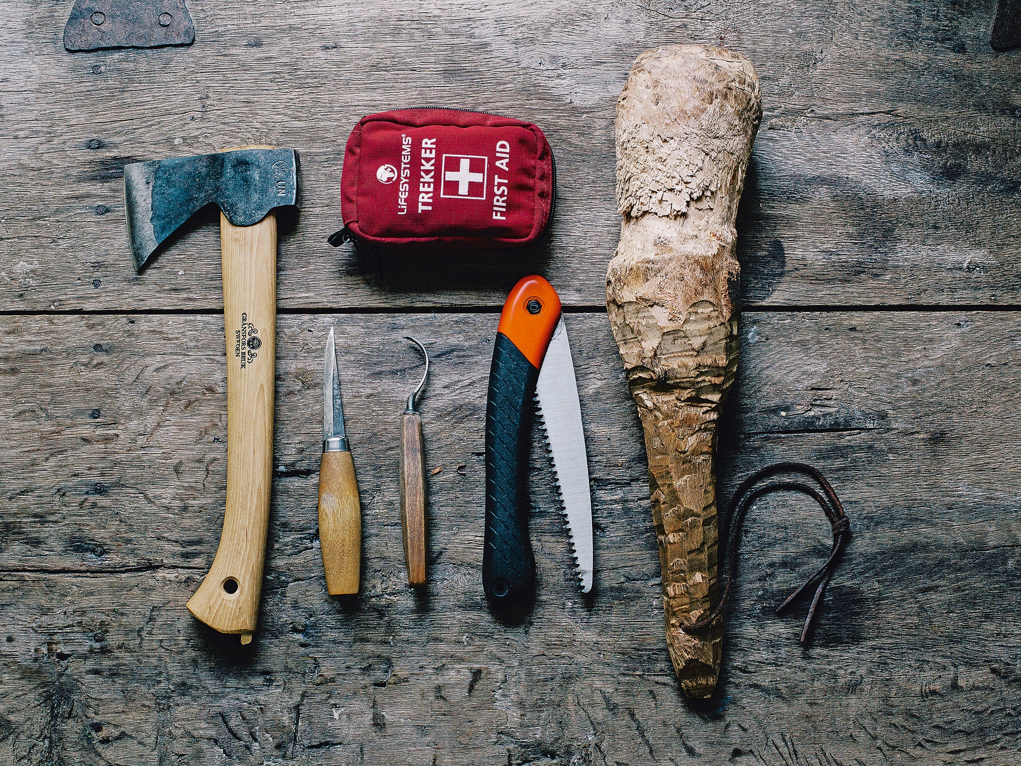 The spoon carving kit list - a small axe, straight-edge knife, crook knife and folding saw (plus a first aid kit)