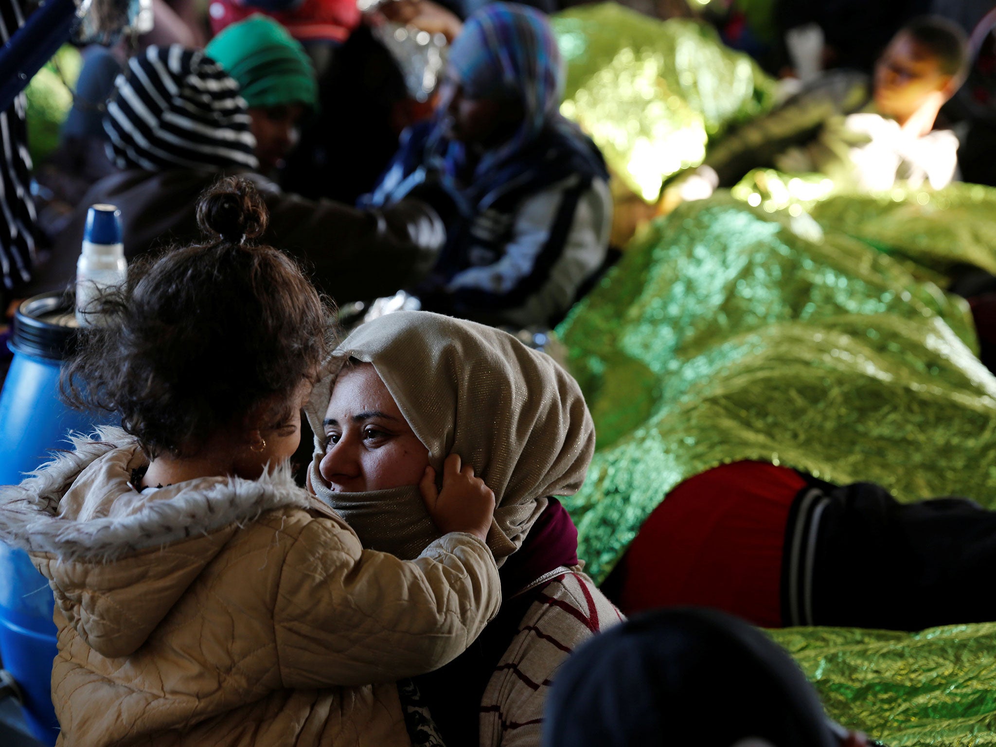 Migrants rest on the Moas ship Phoenix after being rescued off the Libyan coast, as the ship makes its way towards the Italian island of Sicily on 18 April