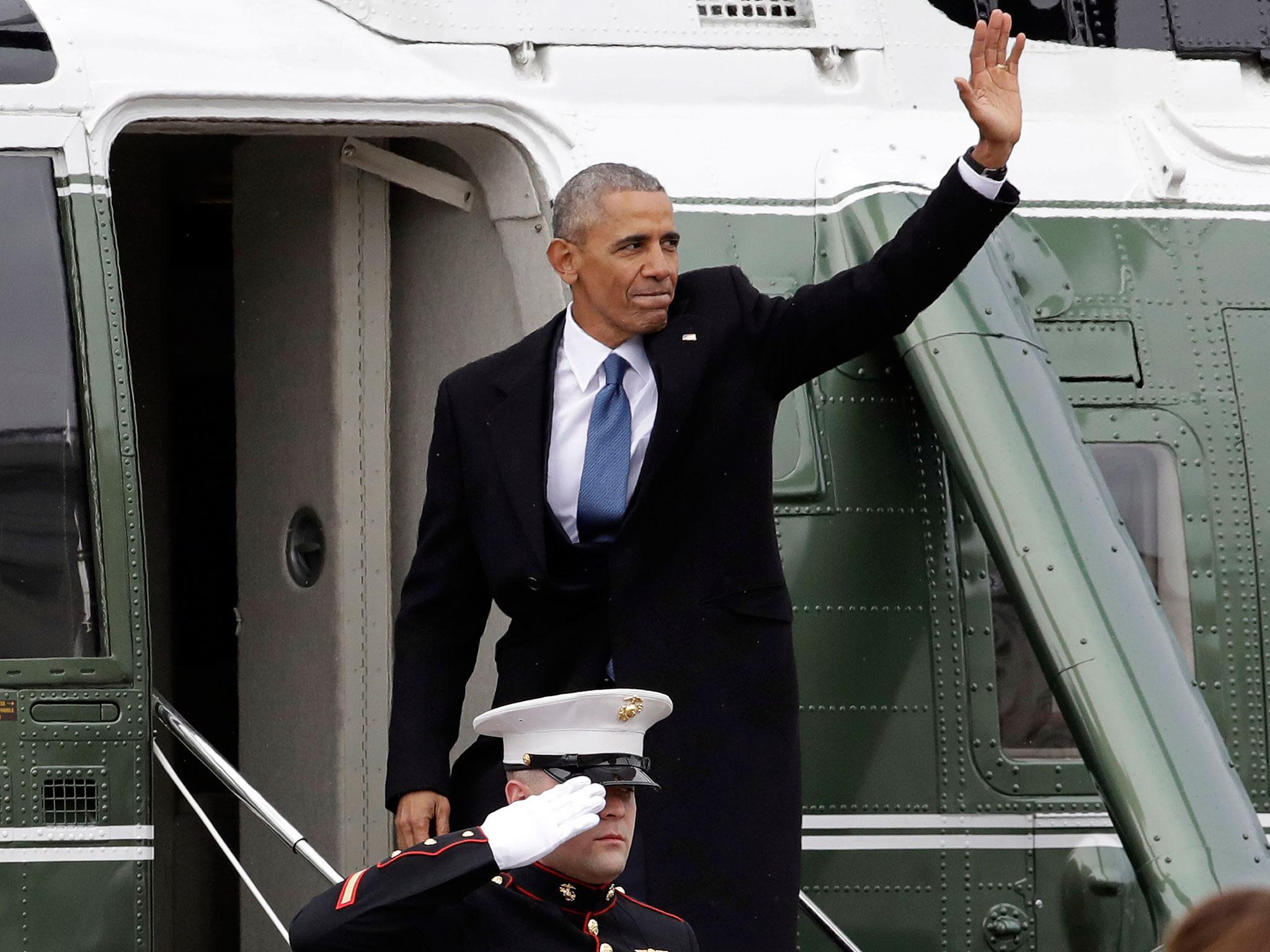 Former President Barack Obama waves as he boards a Marine helicopter