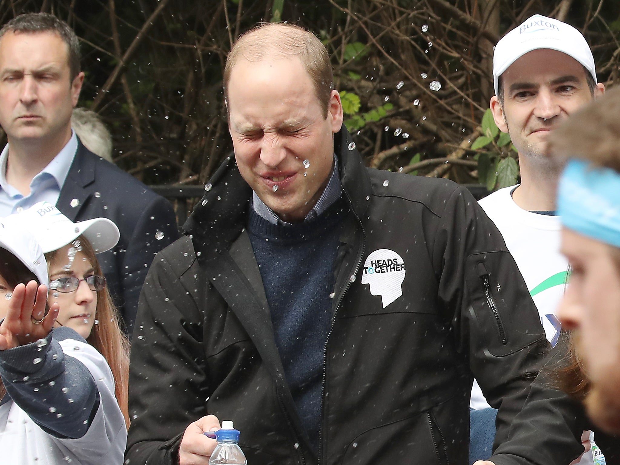 A runner squirts water towards Prince William, Duke of Cambridge as he hands out water to runners during the 2017 Virgin Money London Marathon