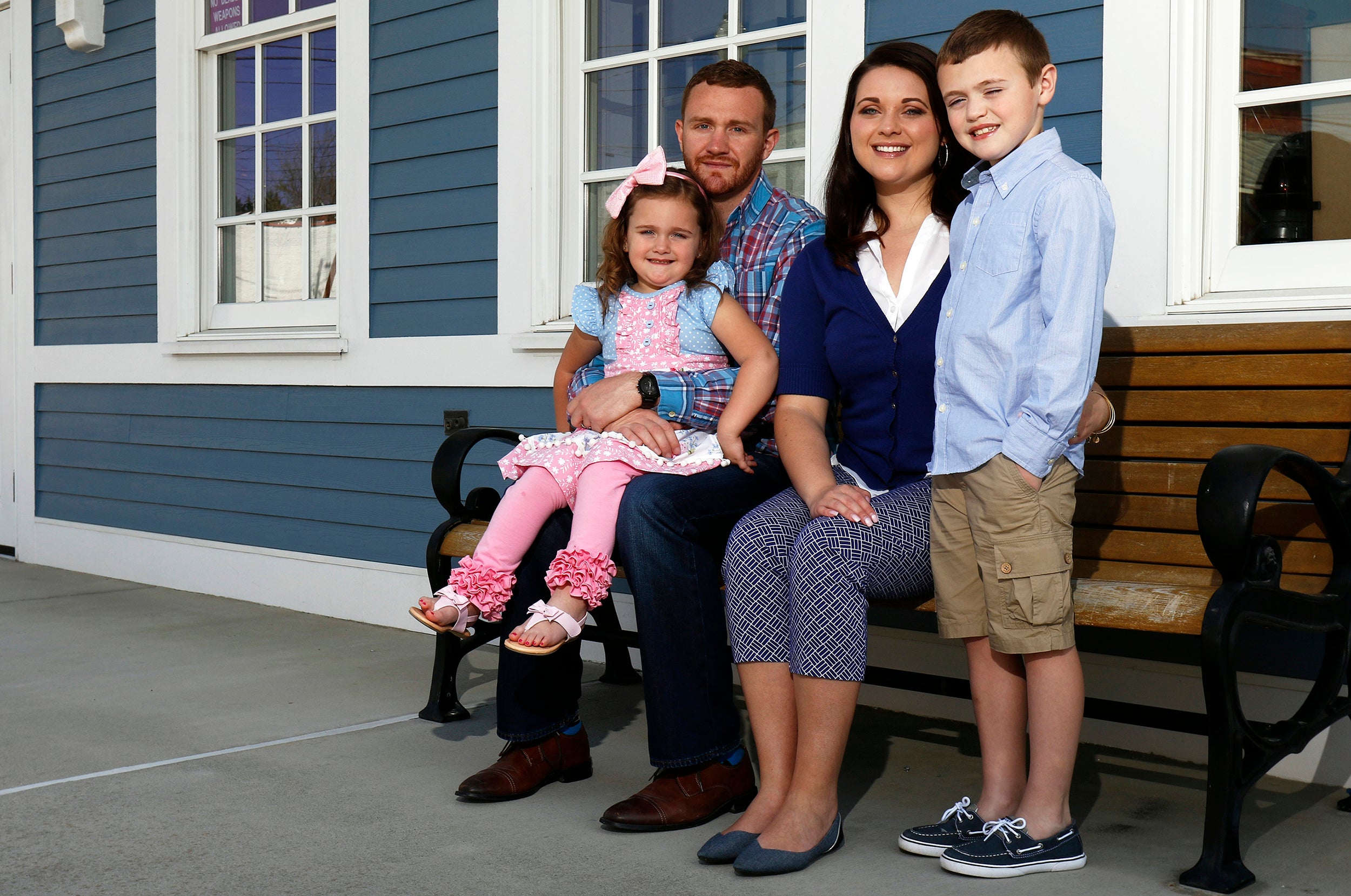 Brett and Courtney Tolliver sit with their daughter, EllaKate, 4, and son, Trenton, 7, at the train depot in Princeton, West Virginia