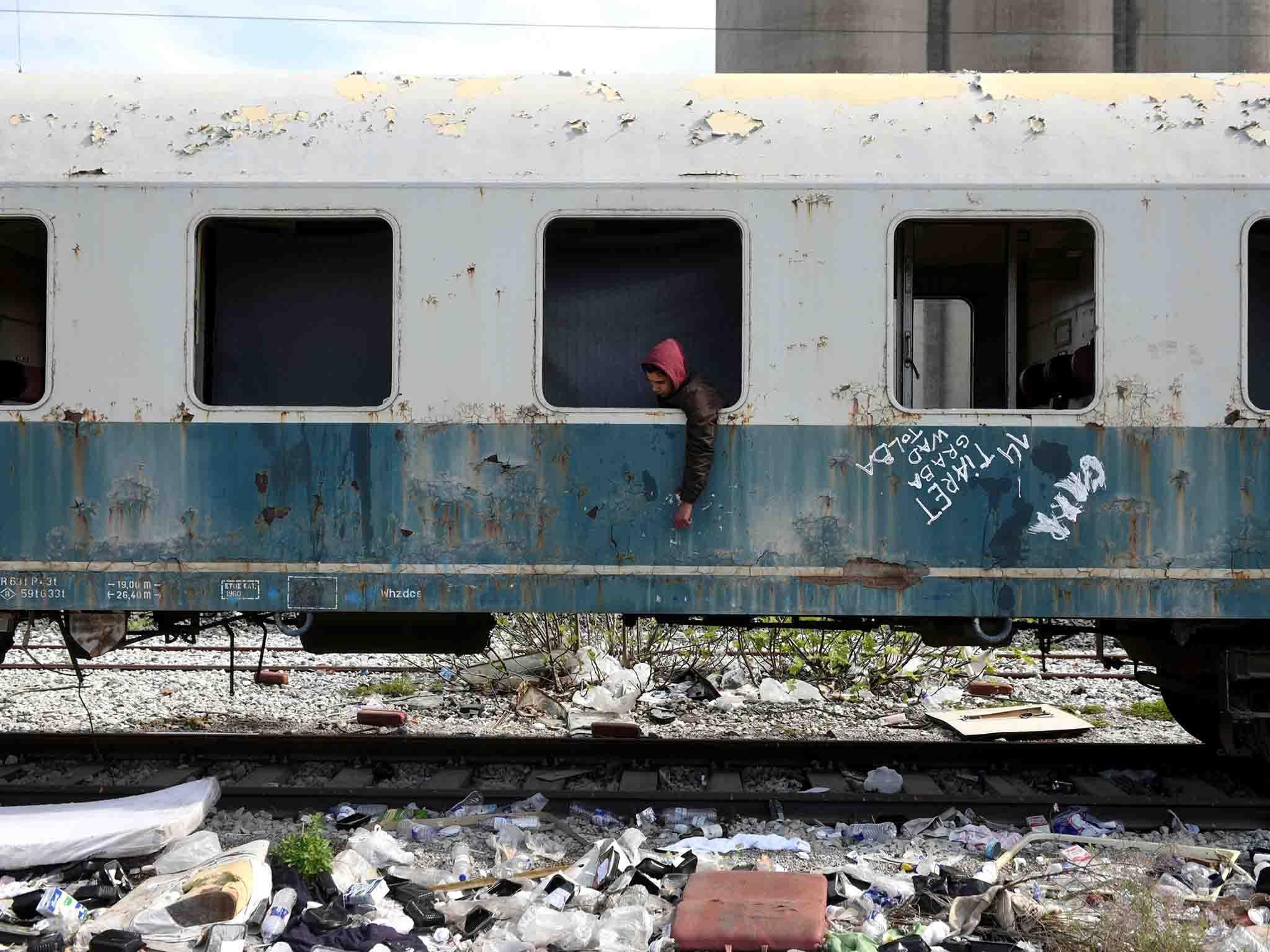 Habib, 22, from Algeria sits in an abandoned railway wagon used as a shelter by stranded migrants. Habib arrived at the Greek island of Rhodes three months ago and he reached the mainland after hiding in a truck on a passenger ferry to Athens