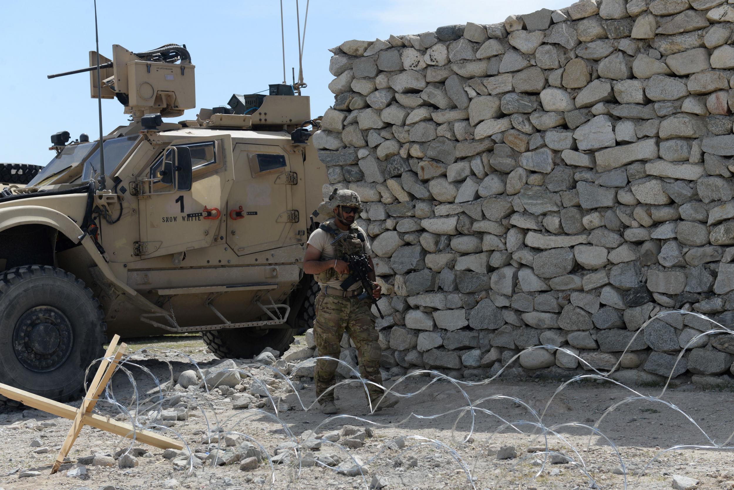 A US soldier patrols the area near the site where the MOAB was dropped in the Achin district of Nangarhar province in Afghanistan