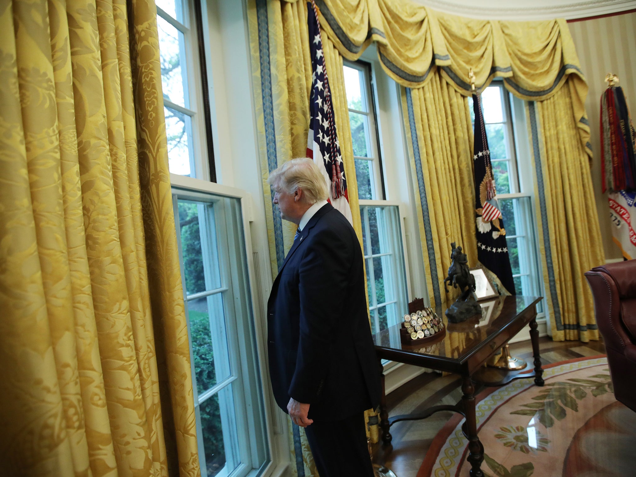 President Donald Trump looks out of a window in the Oval Office (REUTERS)