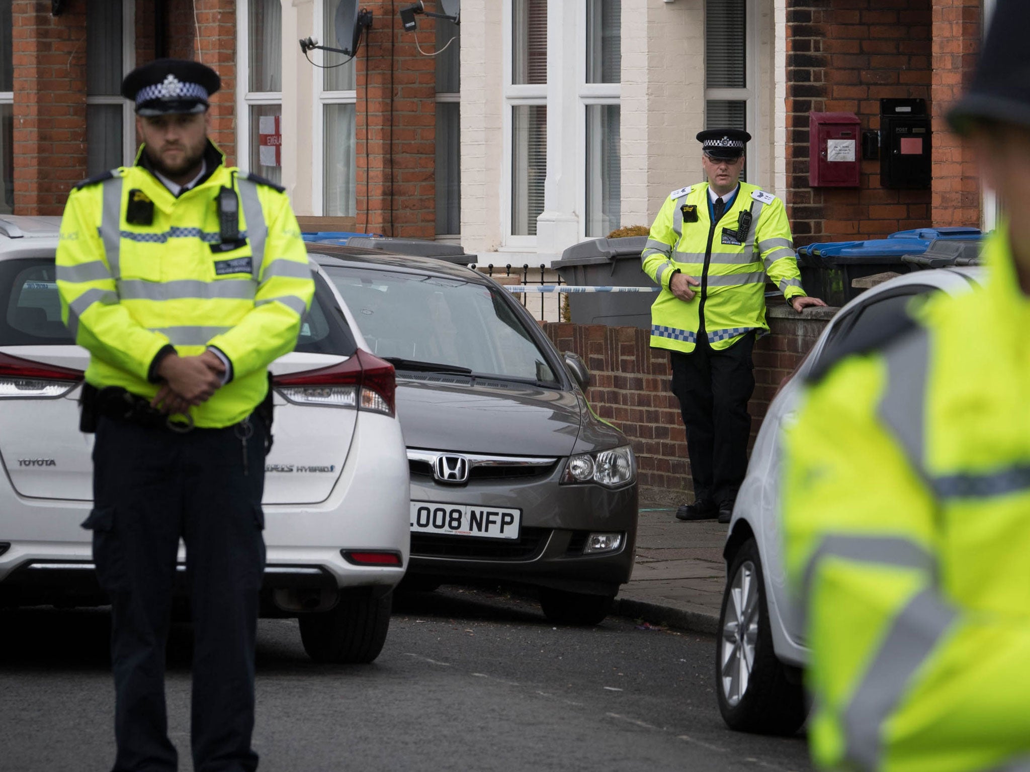 Police at the scene in Harlesden Road, London, where a woman was shot and injured