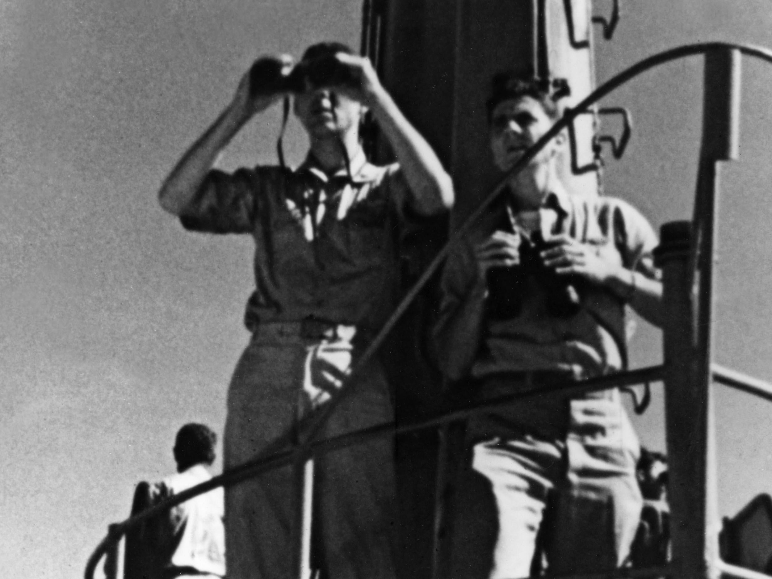 John Ford watches a dogfight over the Pacific through binoculars during the Battle of Midway