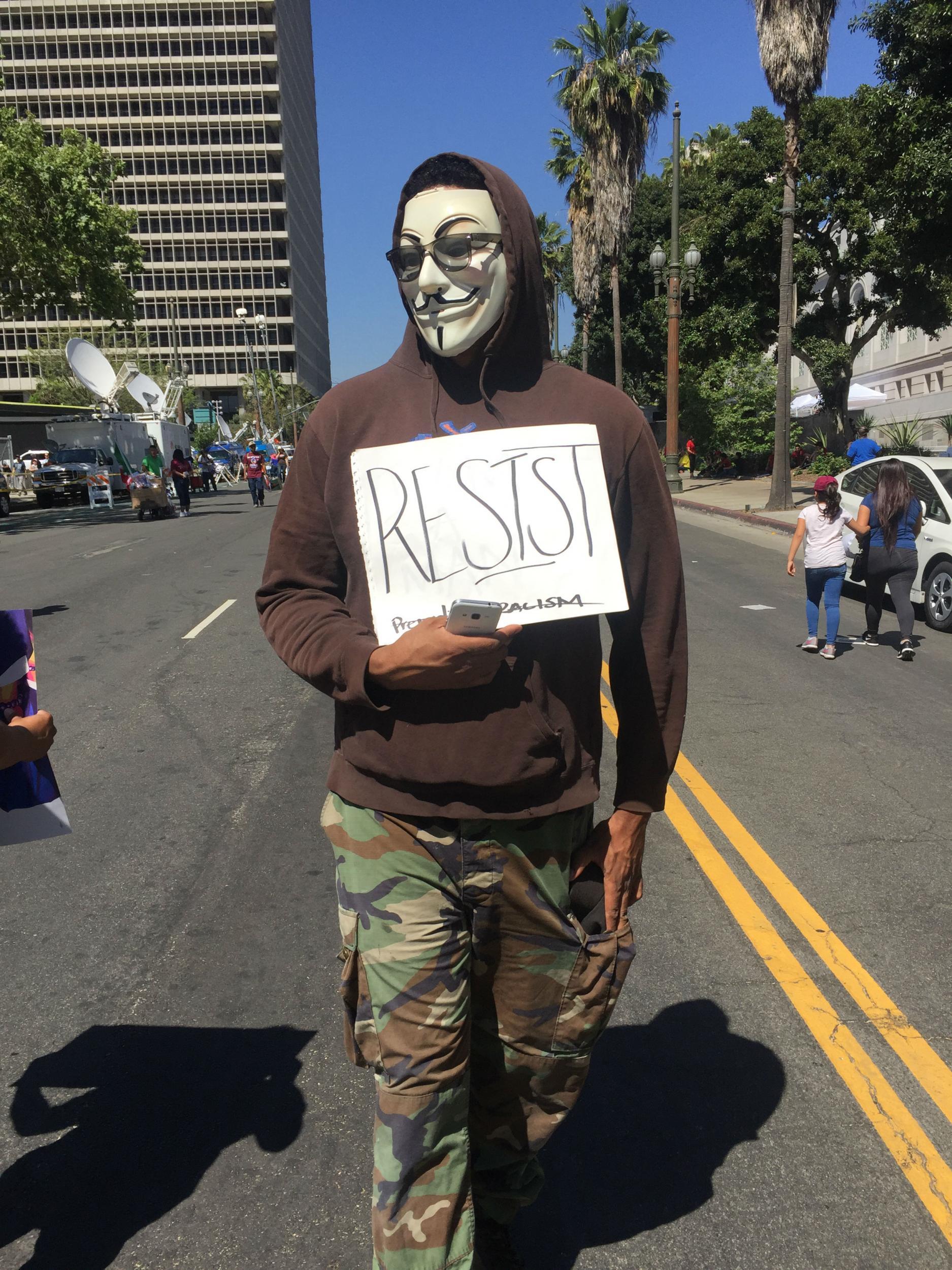 An anti-Trump protestor strolls away from the main stage