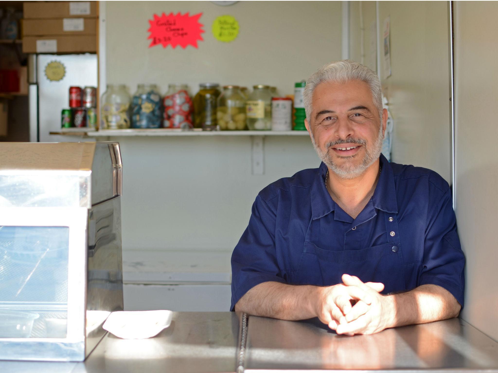 Kazem Hakimi at his fish and chip shop in East Oxford where he takes photos of his customers