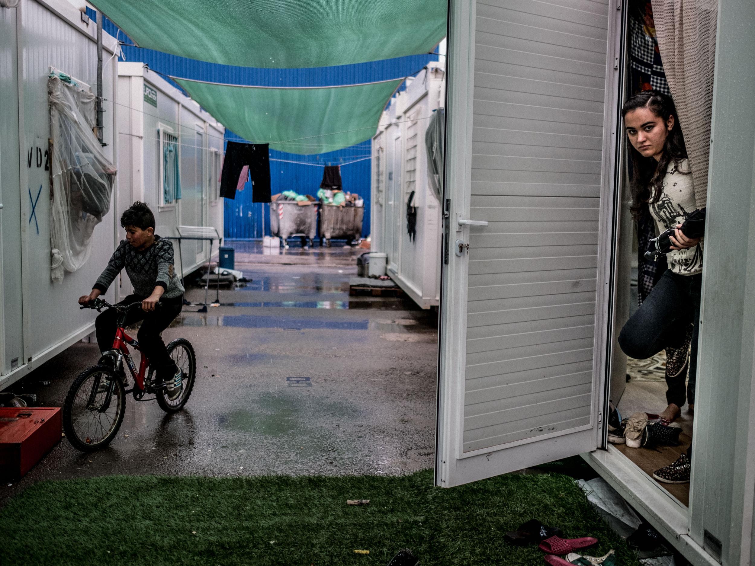 Azhar Khalil, 18, from Syria, looks out of her family’s shelter at Skaramangas Refugee Camp in northern Athens, Greece