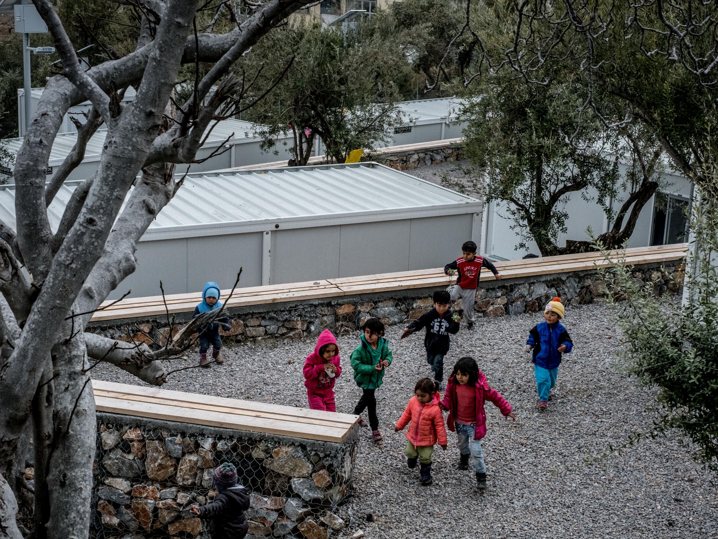 Children play among Iso-boxes, containers converted into refugee shelters, at Kara Tepe refugee camp in Lesvos, Greece