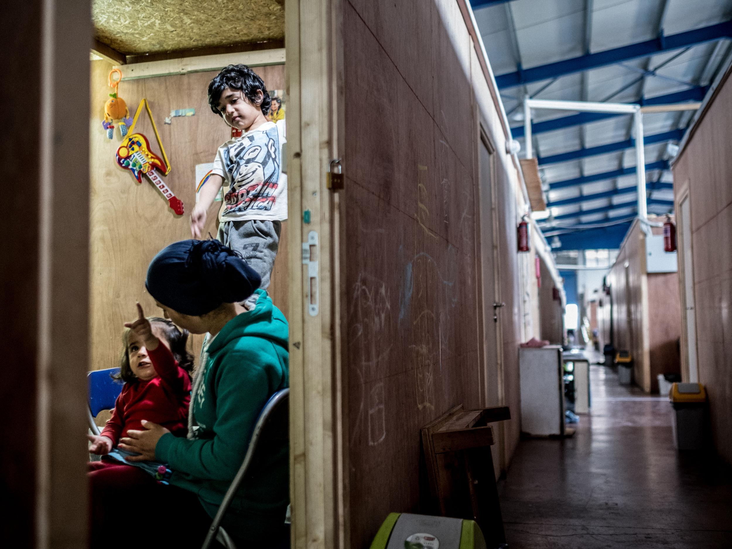 Rosa Hamy, 28, and her children, two year-old Arin and Mohammad, six, from Al Raqqa, Syria, in their unit at the Sinatex Kavalri refugee camp near Thessaloniki, Greece