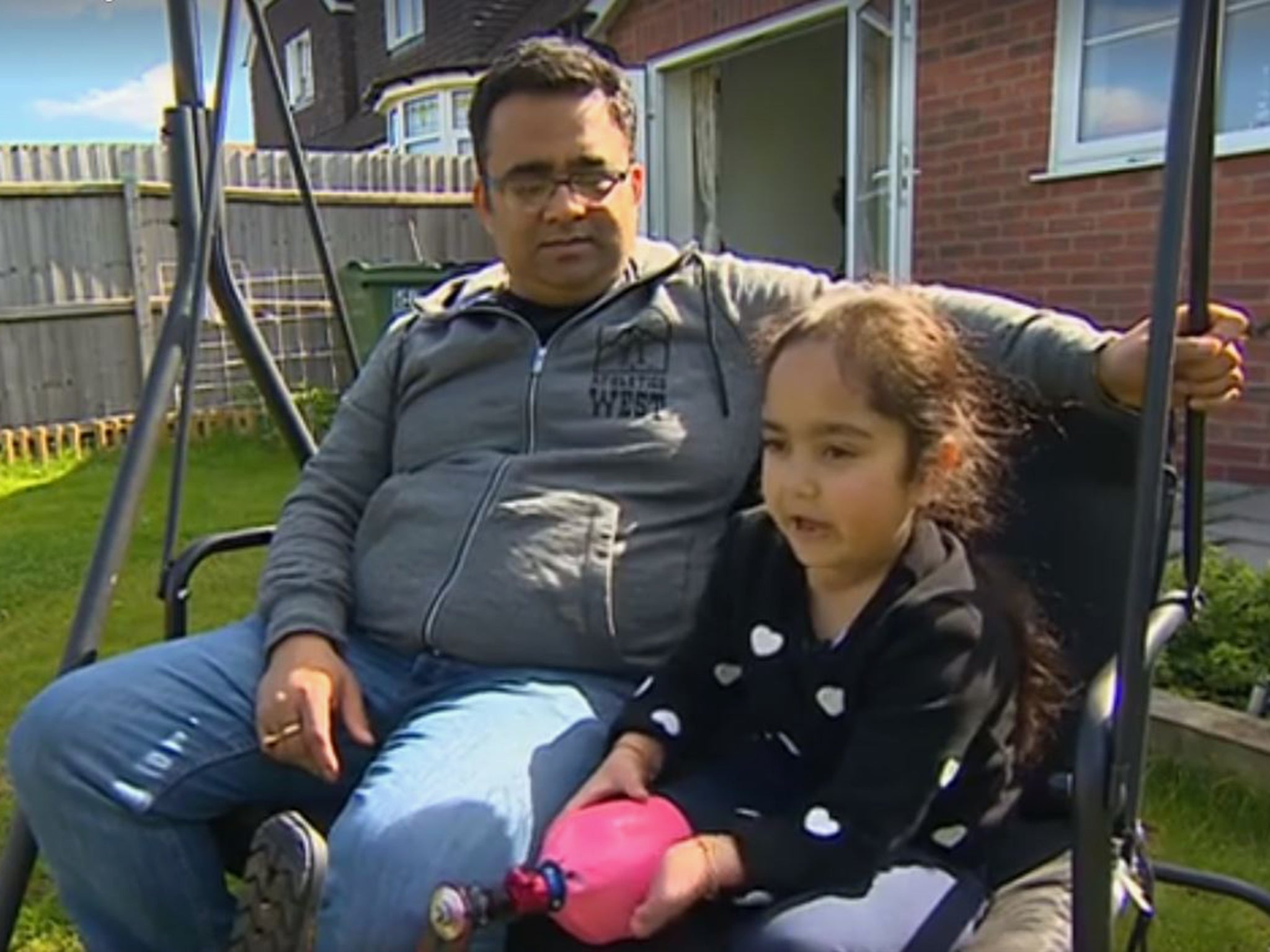 Anu with her father, as she explains what her prosthetic leg is like.