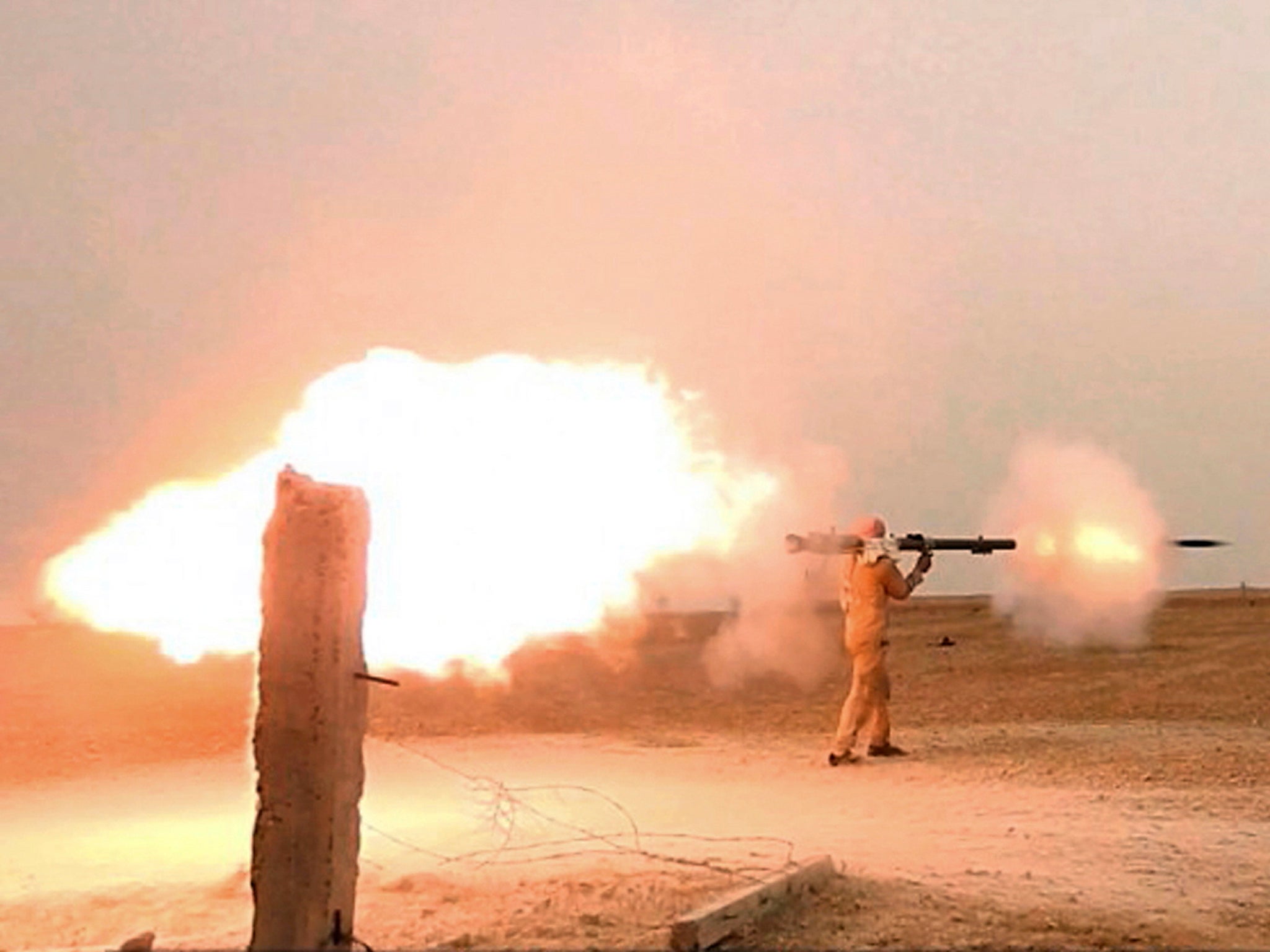 An Islamic State fighter firing his weapon during clashes with US-backed Kurdish-led Syrian Democratic Forces, in the northern Syrian province of Raqqa