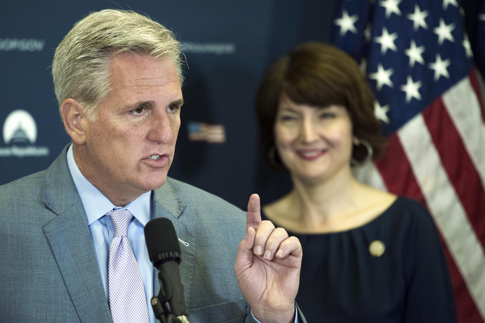 Majority Leader Kevin McCarthy speaks with reporters, as Representative Cathy McMorris-Rodgers looks on.