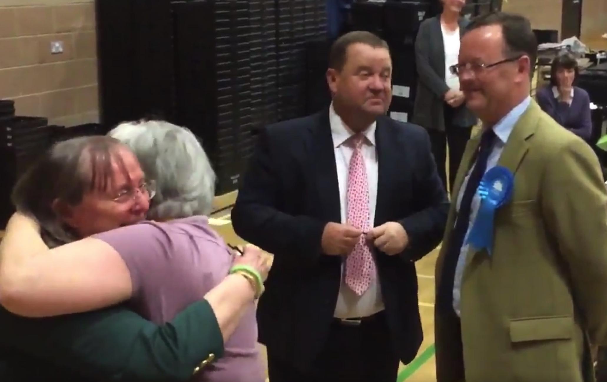 Liberal Democrats celebrate as the defeated Conservative candidate looks on