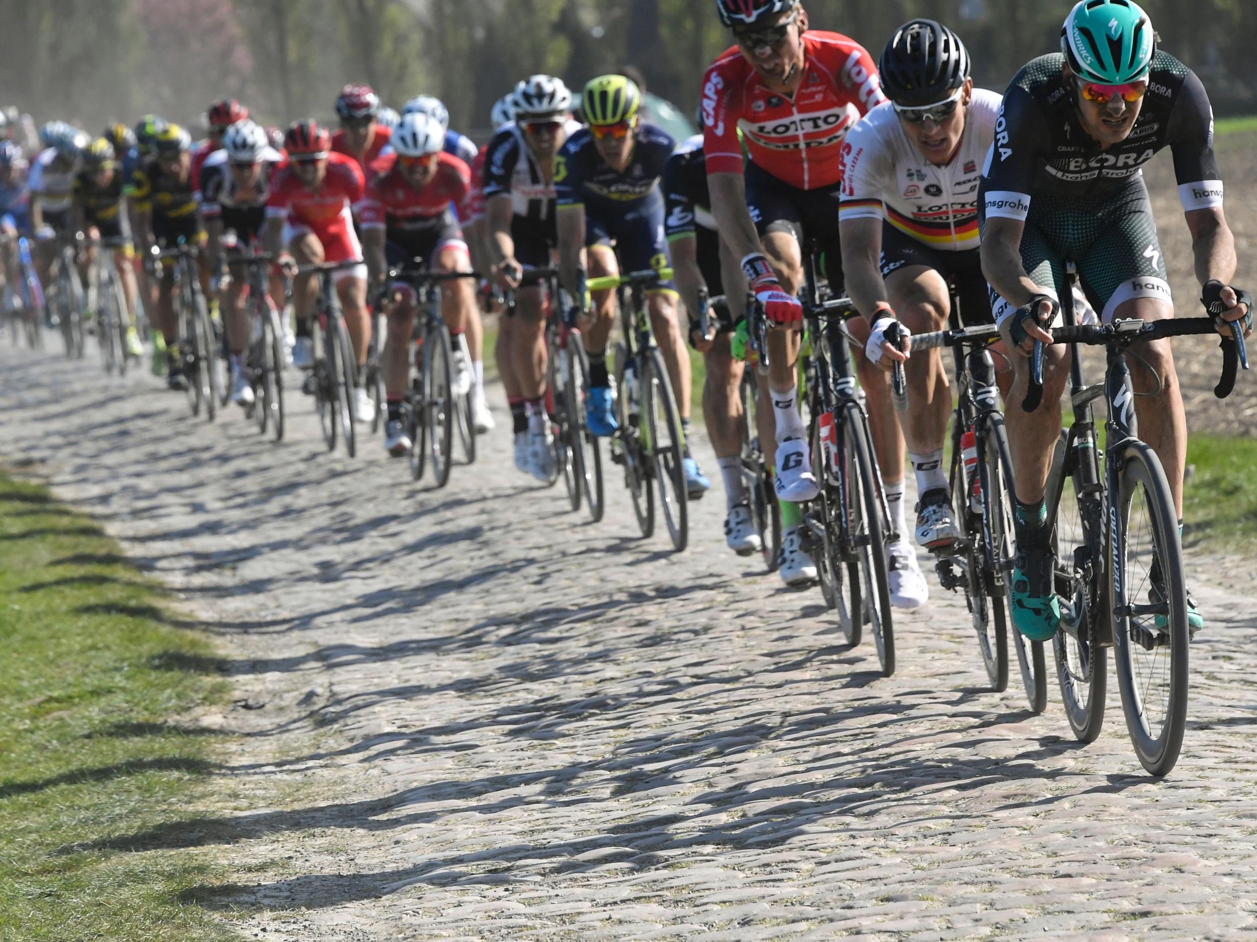 The riders cross the cobblestones