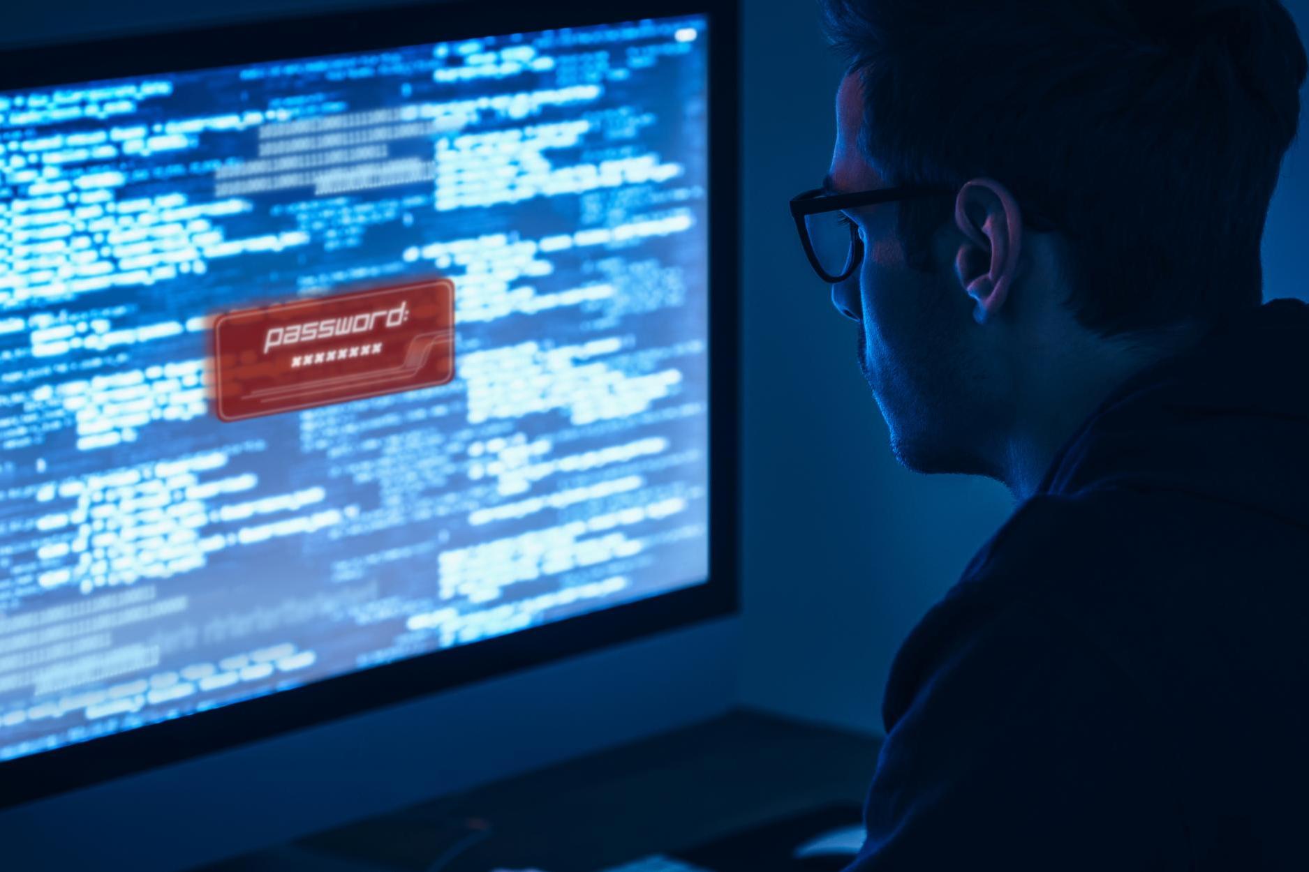 Picture: Man typing and looking at a computer monitor/