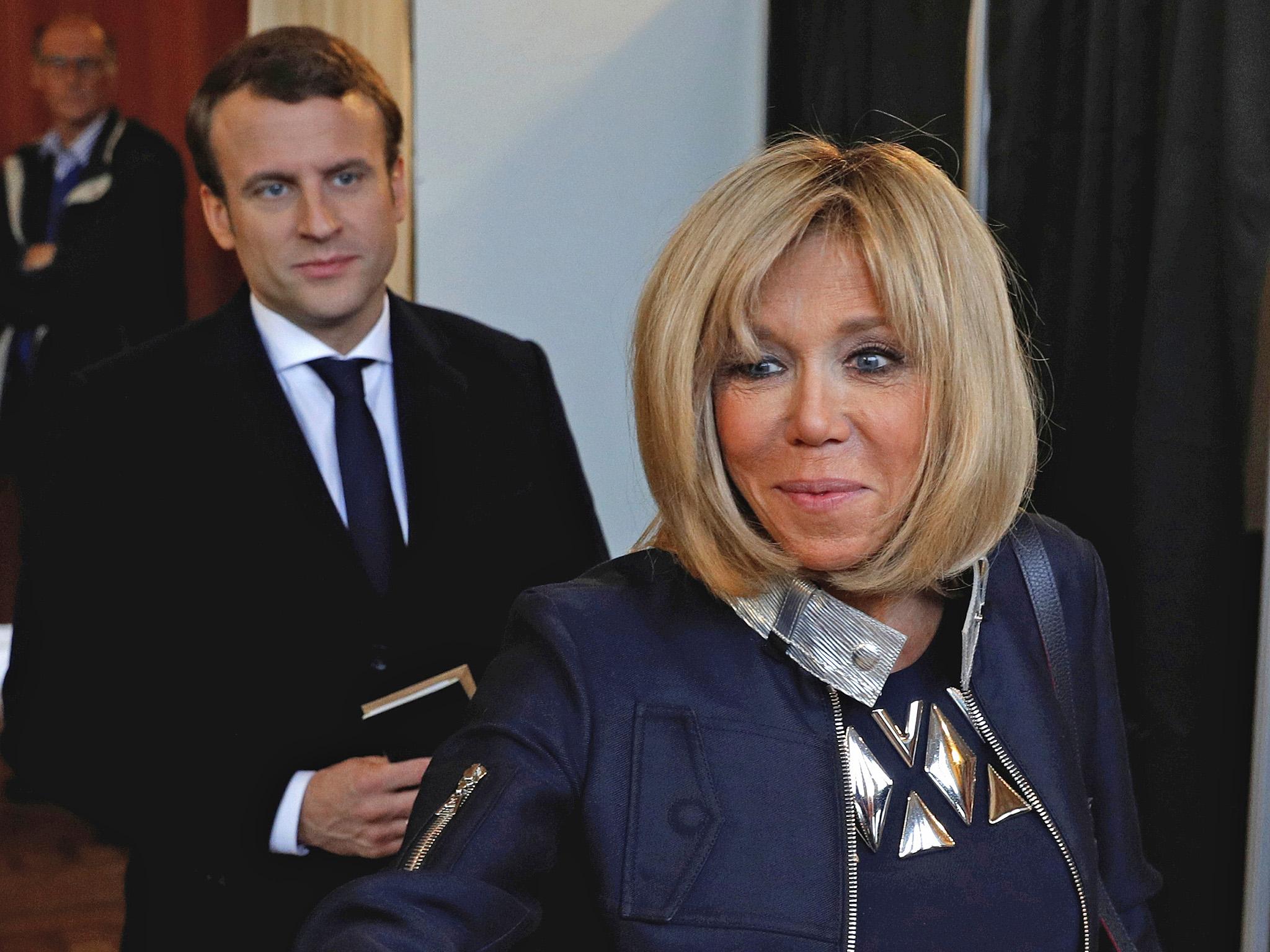 Brigitte Macron votes while her husband looks on