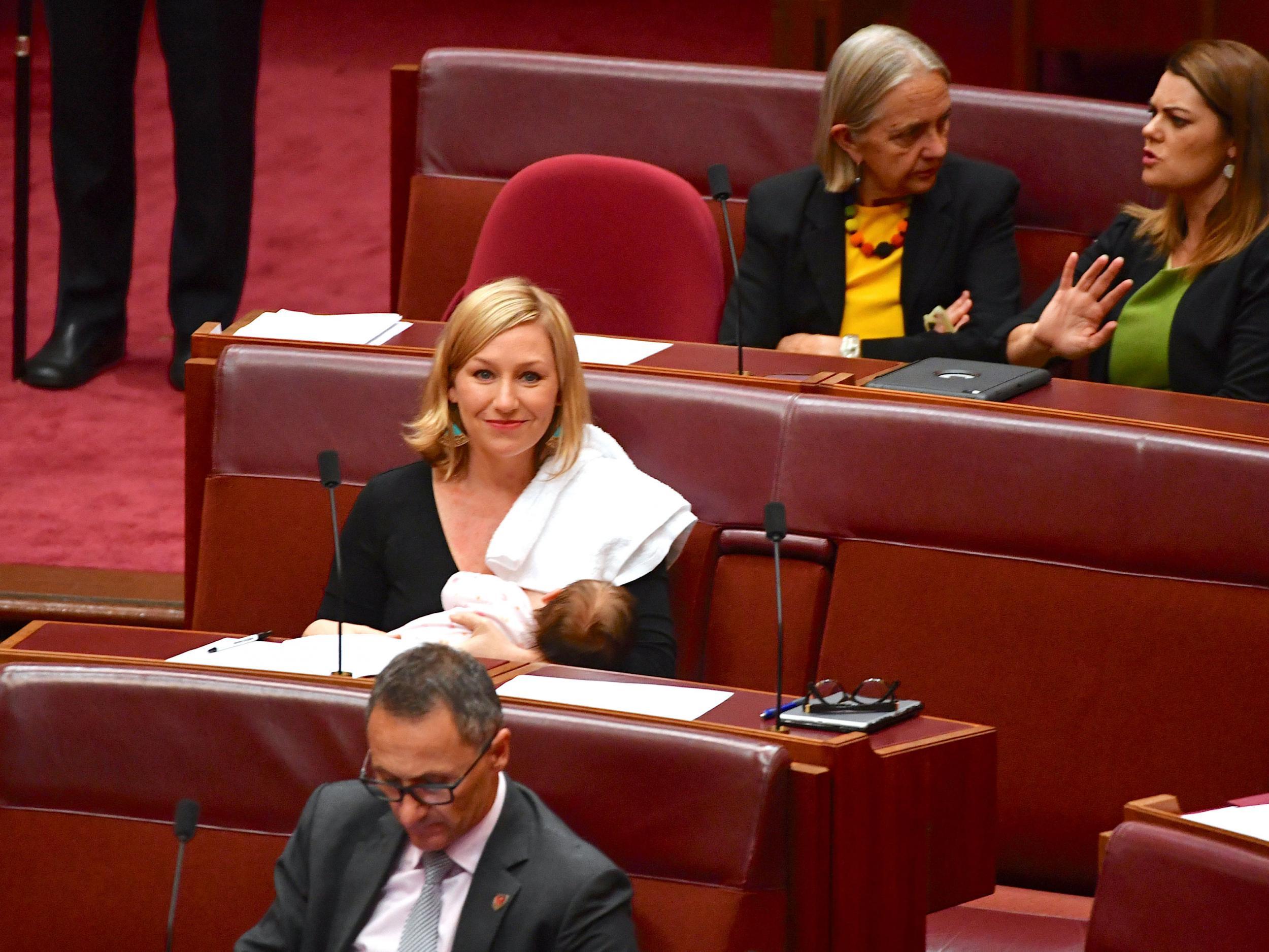 Australian Senator Larissa Waters reacts as she breastfeeds her baby in the Senate Chamber at Parliament House in Canberra