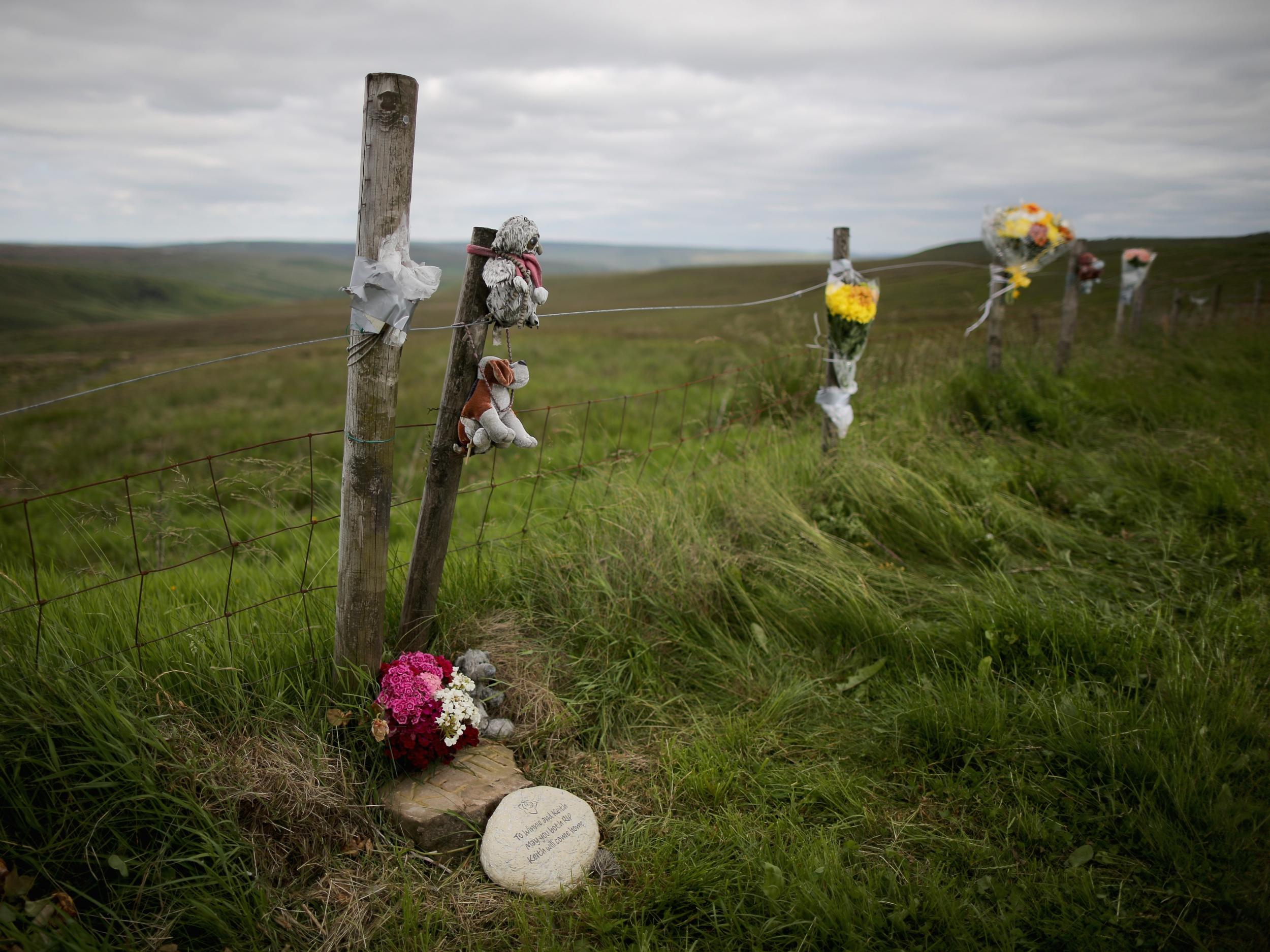 A plaque in memory of Keith Bennett and his mother Winnie Johnson sits next to floral tributes overlooking Saddleworth Moor