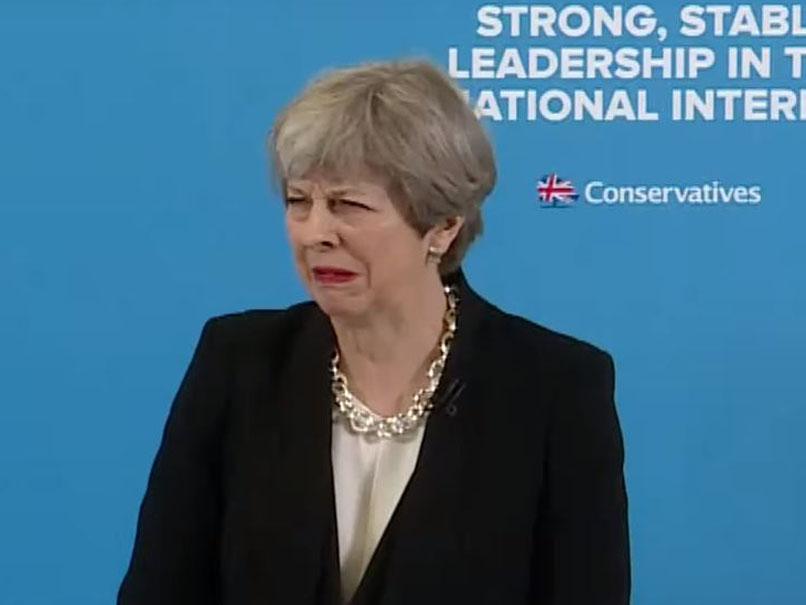 Theresa May grimaces during press conference