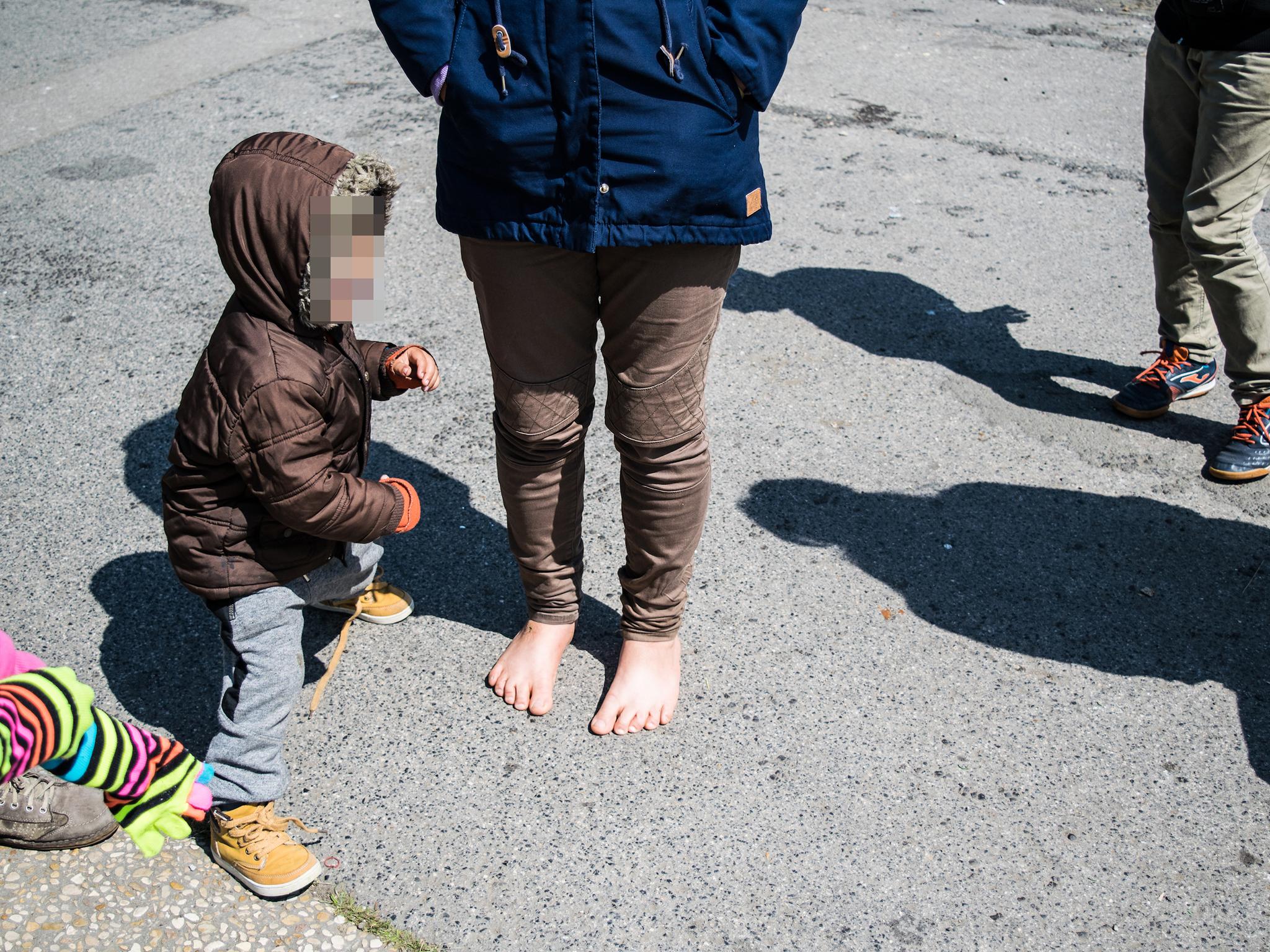 Aid organisations frequently run out of supplies, leaving many – including this young refugee mother – without footwear or suitable clothing